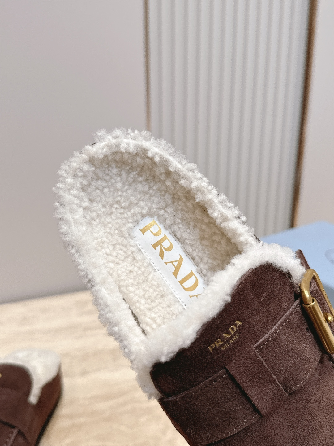 Prada 普拉达 26 秋冬皮带扣复古包头半拖毛拖 这双毛拖无疑是先锋美学与慵懒格调的惊艳融合。标志性的ALAIA皮带