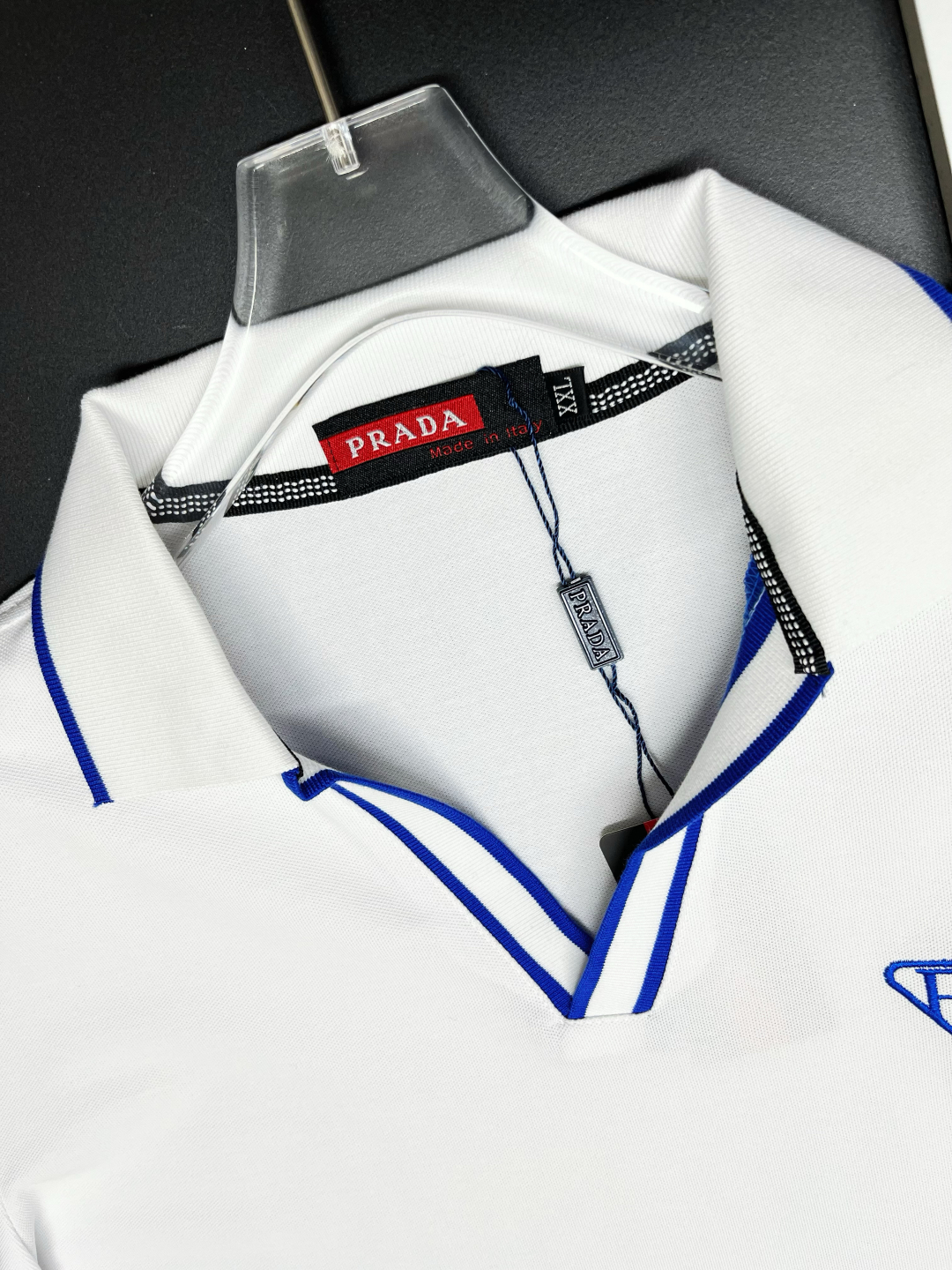 P120
  PRADA 普拉达  V领刺绣新款Polo衫
原版面料 原版订制辅料 官方同款 
采用210克丝光珠地面料，定制 同缸染面料  手感非常舒服爽滑  版型挺阔有型 
一线品牌代工厂出品 进口百灵达刺绣机器 刺绣饱满有质感
衣领袖口罗纹采用进口纱线织造 久穿不变形
春夏最新款式  时尚又个性  超级百搭好看的一款                
男女都非常合适  人手必备款 
颜色: 黑色 白色 红色
尺码：M-3XL