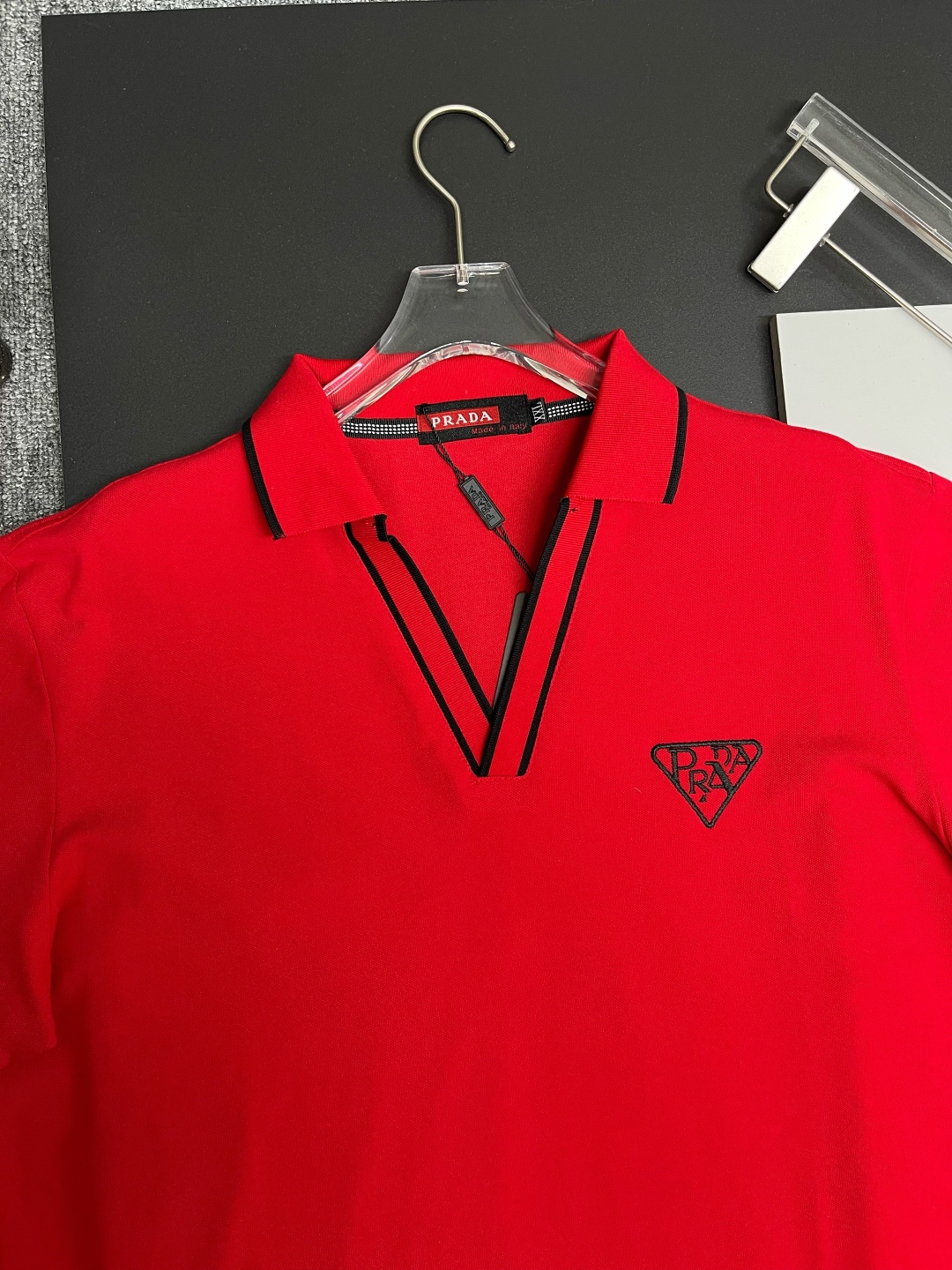 P120
  PRADA 普拉达  V领刺绣新款Polo衫
原版面料 原版订制辅料 官方同款 
采用210克丝光珠地面料，定制 同缸染面料  手感非常舒服爽滑  版型挺阔有型 
一线品牌代工厂出品 进口百灵达刺绣机器 刺绣饱满有质感
衣领袖口罗纹采用进口纱线织造 久穿不变形
春夏最新款式  时尚又个性  超级百搭好看的一款                
男女都非常合适  人手必备款 
颜色: 黑色 白色 红色
尺码：M-3XL