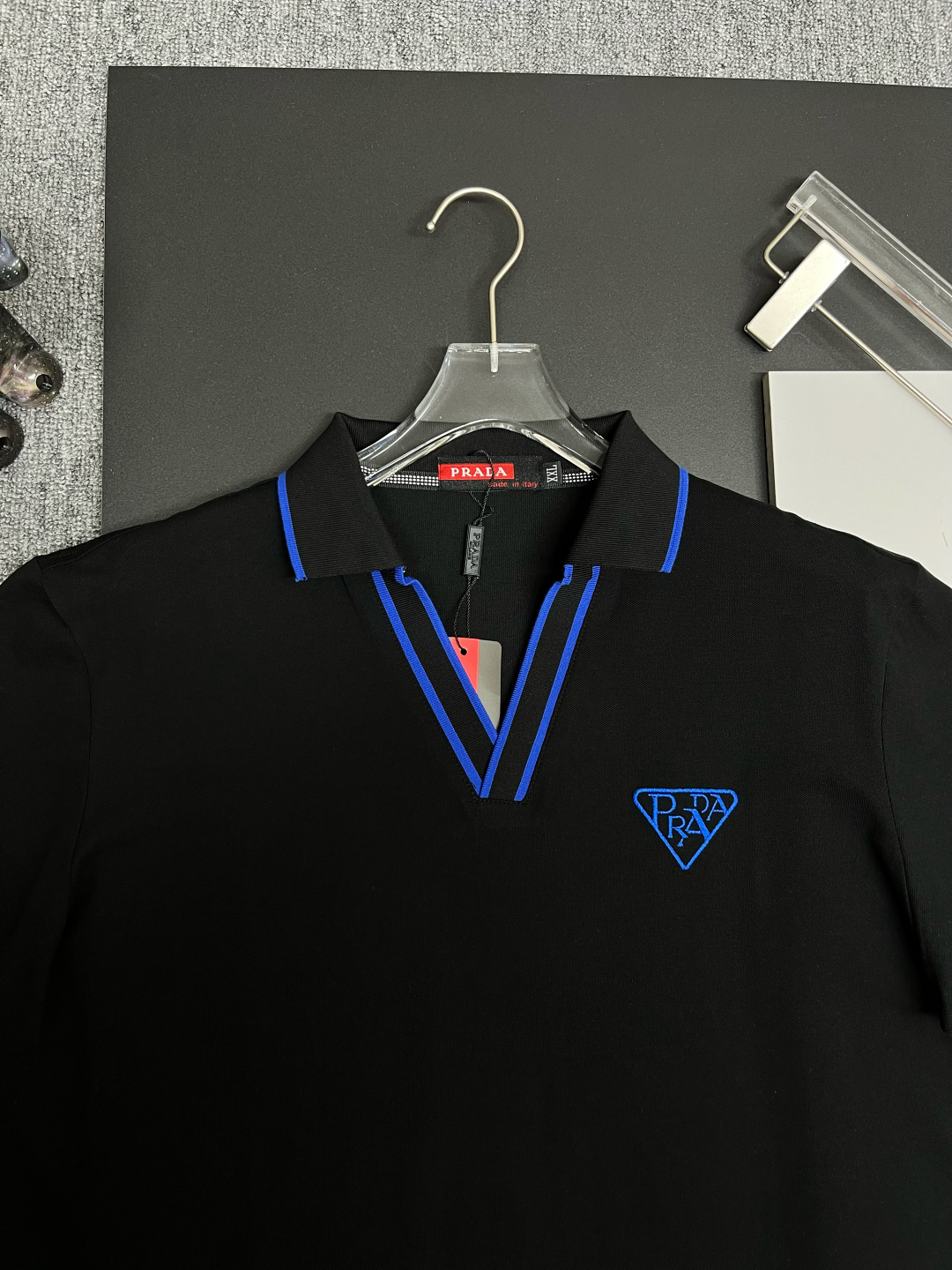 P120
  PRADA 普拉达  V领刺绣新款Polo衫
原版面料 原版订制辅料 官方同款 
采用210克丝光珠地面料，定制 同缸染面料  手感非常舒服爽滑  版型挺阔有型 
一线品牌代工厂出品 进口百灵达刺绣机器 刺绣饱满有质感
衣领袖口罗纹采用进口纱线织造 久穿不变形
春夏最新款式  时尚又个性  超级百搭好看的一款                
男女都非常合适  人手必备款 
颜色: 黑色 白色 红色
尺码：M-3XL