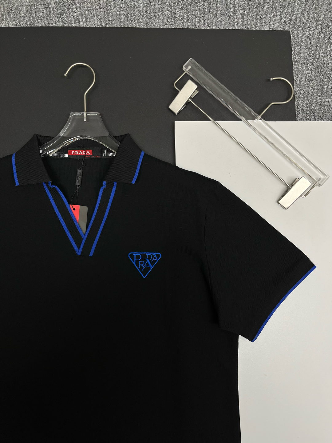 P120
  PRADA 普拉达  V领刺绣新款Polo衫
原版面料 原版订制辅料 官方同款 
采用210克丝光珠地面料，定制 同缸染面料  手感非常舒服爽滑  版型挺阔有型 
一线品牌代工厂出品 进口百灵达刺绣机器 刺绣饱满有质感
衣领袖口罗纹采用进口纱线织造 久穿不变形
春夏最新款式  时尚又个性  超级百搭好看的一款                
男女都非常合适  人手必备款 
颜色: 黑色 白色 红色
尺码：M-3XL