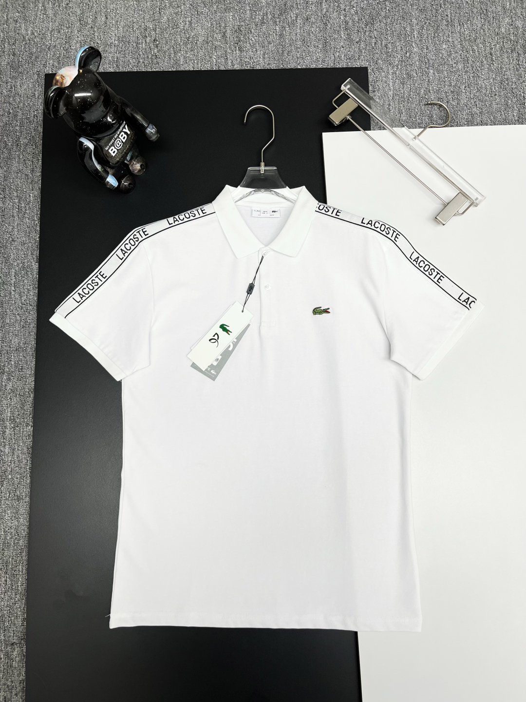 PZY \nLACOSTE 鳄鱼 织带刺绣新款Polo衫\n原版面料 原版订制辅料 官方同款 \n采用ZY克纯棉珠地面料，定制 同缸染面料  手感非常舒服爽滑  版型挺阔有型 \n一线品牌代工厂出品 进口百灵达刺绣机器 刺绣饱满有质感\n衣领袖口罗纹采用进口纱线织造 久穿不变形\n春夏最新款式  时尚又个性  超级百搭好看的一款                \n男女都非常合适  人手必备款 \n颜色: 黑色 白色 粉色\n尺码：M-XXXL