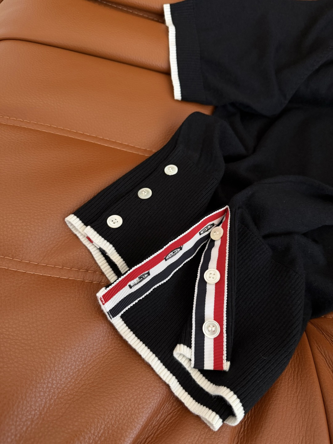 26春夏 镂空水滴形状设计针织上衣 经典的黑白撞色真的百穿不厌 下摆双侧加入了经典织带的拼接开叉设计 很