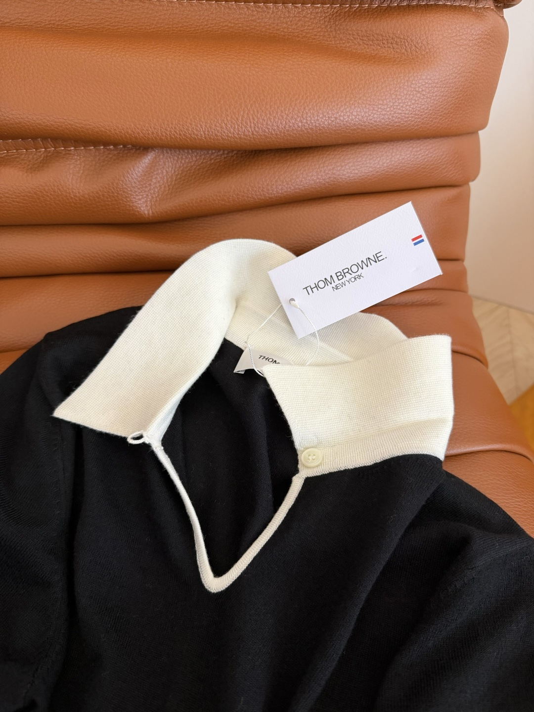 26春夏 镂空水滴形状设计针织上衣 经典的黑白撞色真的百穿不厌 下摆双侧加入了经典织带的拼接开叉设计 很