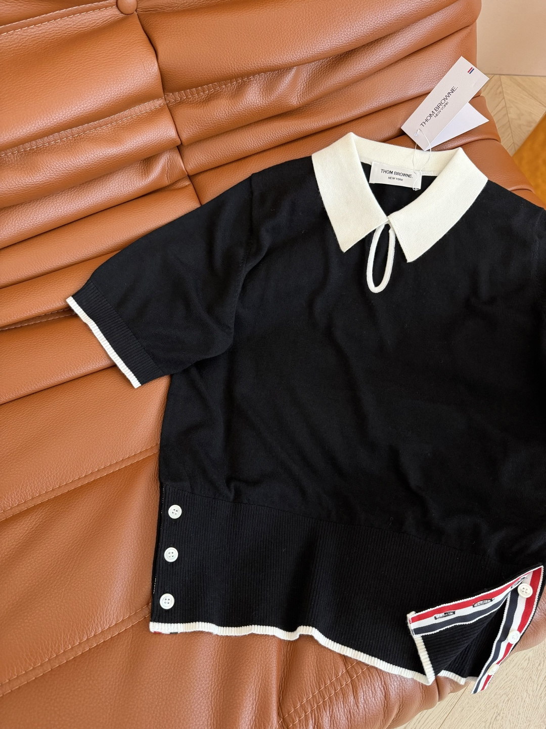 26春夏 镂空水滴形状设计针织上衣 经典的黑白撞色真的百穿不厌 下摆双侧加入了经典织带的拼接开叉设计 很