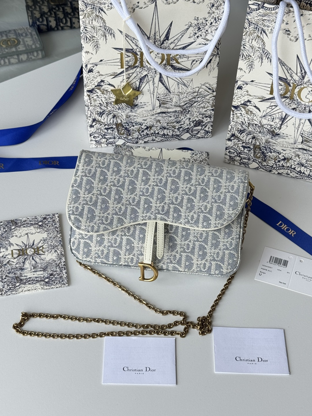 NO:619070,This saddle chain handbag has smooth and harmonious lines, making it a fashionable and practical item. Carefully crafted from blue Denim Dior Oblique jacquard fabric, the classic Dior pattern is reinterpreted with an irregular stonewash effect to highlight the fashionable style. It is equipped with an asymmetric flap and a metal stirrup D-shaped charm with antique gold finish. The spacious internal compartment can store a variety of daily necessities, and it can be worn on the shoulder or cross-body with a chain. It can be easily matched with other saddle series items. Flap closure  No.: S5907CTZQ_M928 Front stirrup D-shaped pendant 1 compartment 6 card slots 1 slip pocket - No. S5097 Dimensions: 21.5x12.5x3.7 cm (LxHxW) Can store 1 mobile phone, 1 card holder and lipstick Chain length: 118 cm  Length from the top of the chain to the top of the bag: 57 cm Weight: about 280 grams, Dior wallet, dior, dior, wallets19860909这款马鞍链条手袋线条流畅协调,是一款时尚且实用的单品.采用蓝色Denim Dior Oblique 提花面料精心制作,以不规则的石洗效果焕新演绎经典的Dior图案,彰显时髦风范,搭配不对称翻盖和复古金色饰面金属马镫D形吊饰.宽敞的内部隔层可收纳各种日常用品,搭配链条,便于肩背或斜挎.可与其他马鞍系列单品轻松搭配. 翻盖开合 编号:S5907CTZQ_M928 正面马镫 D 形吊饰1个隔层6个卡槽1个插袋-编号S5097 尺寸:21.5x12.5x3.7厘米(长x高x宽)可收纳1部手机、1个卡夹和唇膏链条长度:118 厘米 链条顶端至手袋顶端长度:57厘米重量:约280克,迪奥钱包,dior,dior,wallets,Bag