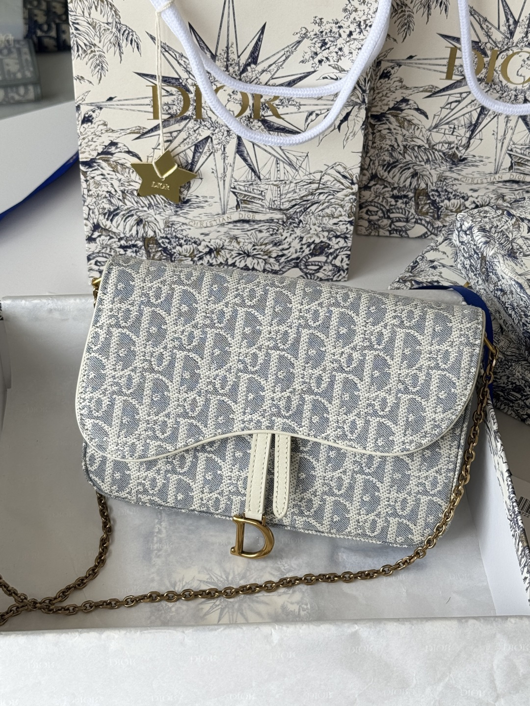 Dior 这款马鞍链条手袋线条流畅协调 是一款 且实用的单品 采用蓝色Denim Dior Oblique 提花面料精心制作