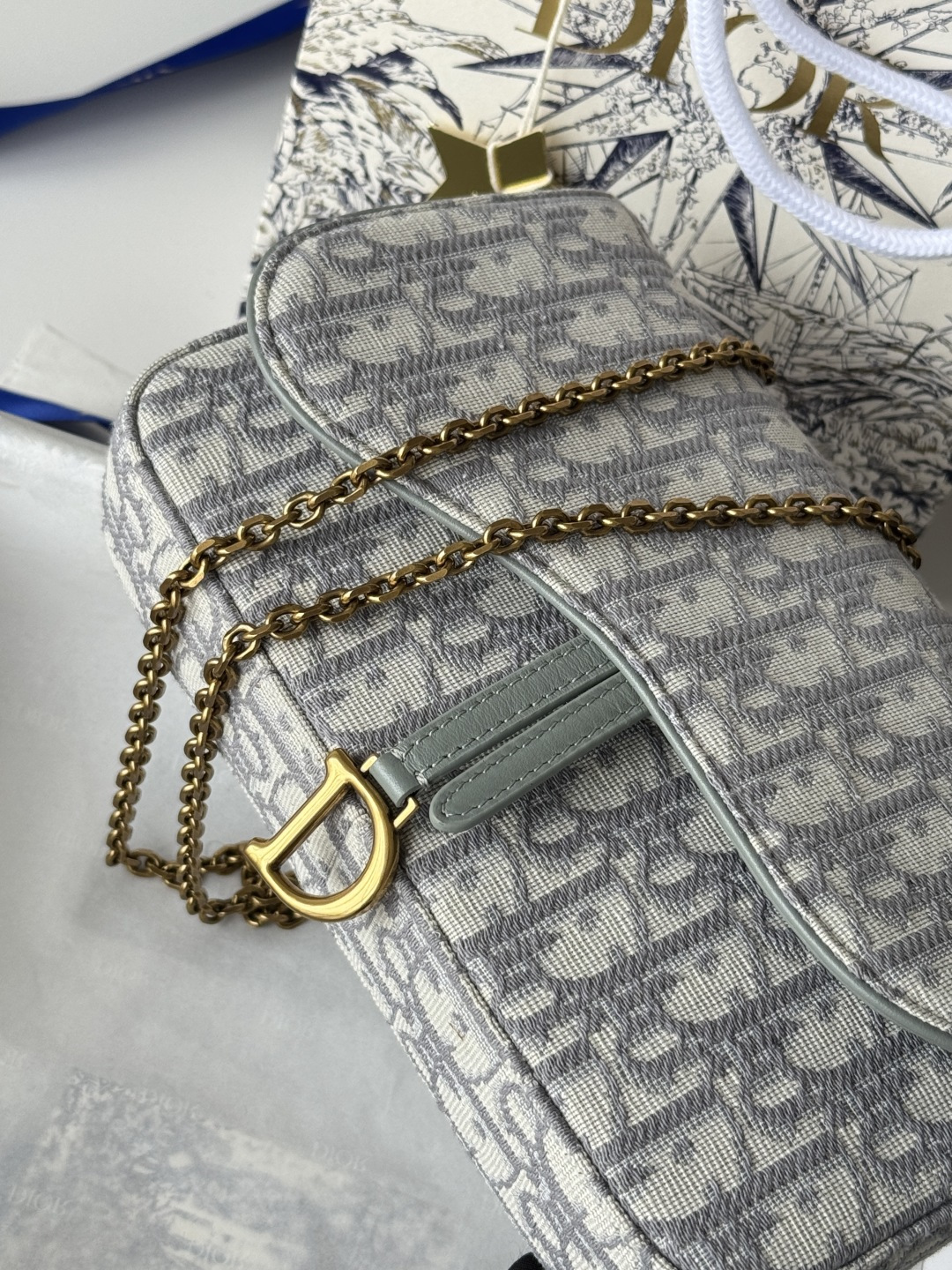 Dior 这款马鞍链条手袋线条流畅协调 是一款 且实用的单品 采用蓝色Denim Dior Oblique 提花面料精心制作