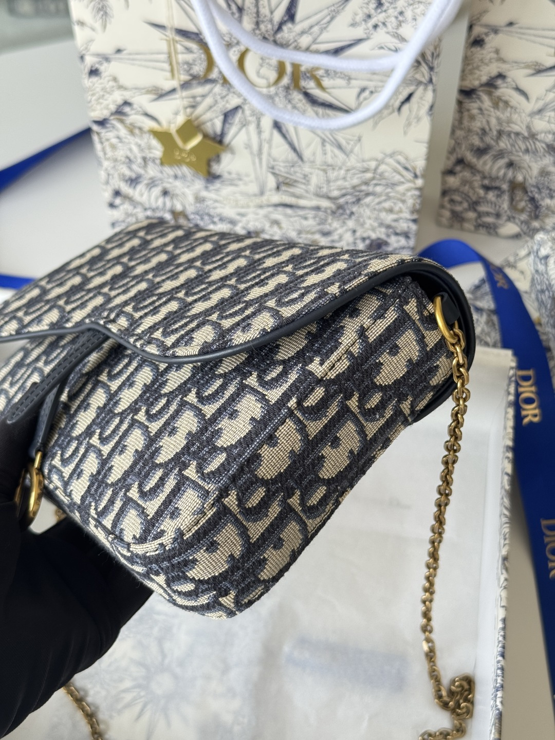 Dior 这款马鞍链条手袋线条流畅协调 是一款 且实用的单品 采用蓝色Denim Dior Oblique 提花面料精心制作