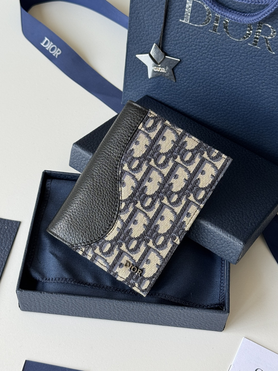 Dior 这款护照套实用而高雅 采用米色和黑色 Oblique 印花面料精心制作 正面饰以 Dior 标志
