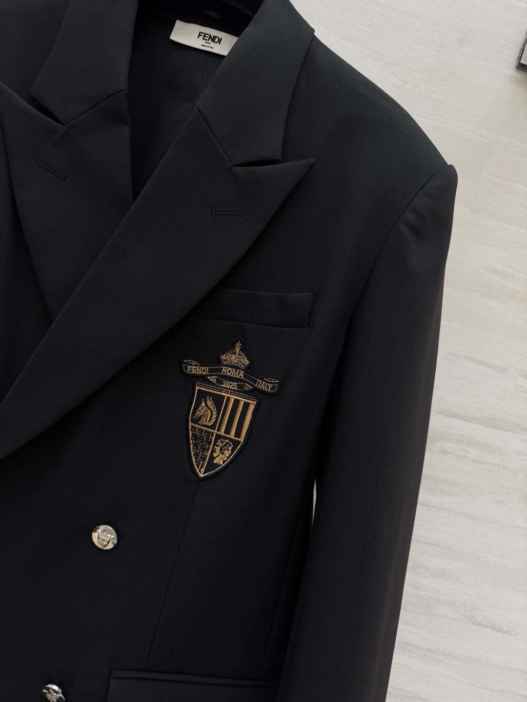 #FEND♡²⁶徽章西装 把贵族学院感穿在身上 经典黑色双排扣剪裁 挺括有型自带气场 胸口金色盾形徽章刺