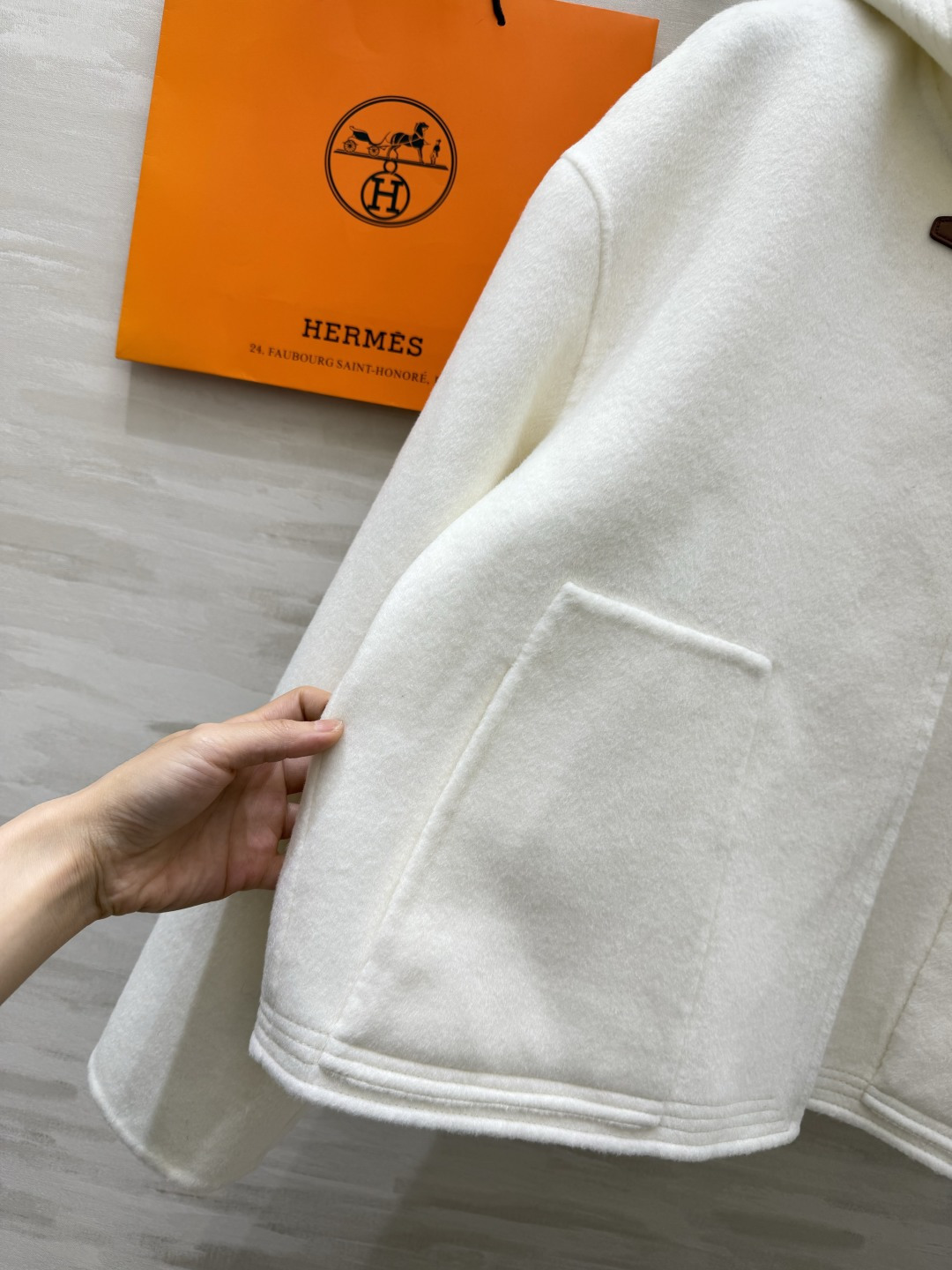 Hermès²⁶连帽短款羊毛大衣|黑白两色 极简连帽短款双面羊毛 利落短版型 上身优化身材比例 领口经典皮扣搭袢设计 复 Hermès²⁶连帽短款羊毛大衣|黑白两色 极简连帽短款双面羊毛 利落短版型 上身优化身材比例 领口经典皮扣搭袢设计 复