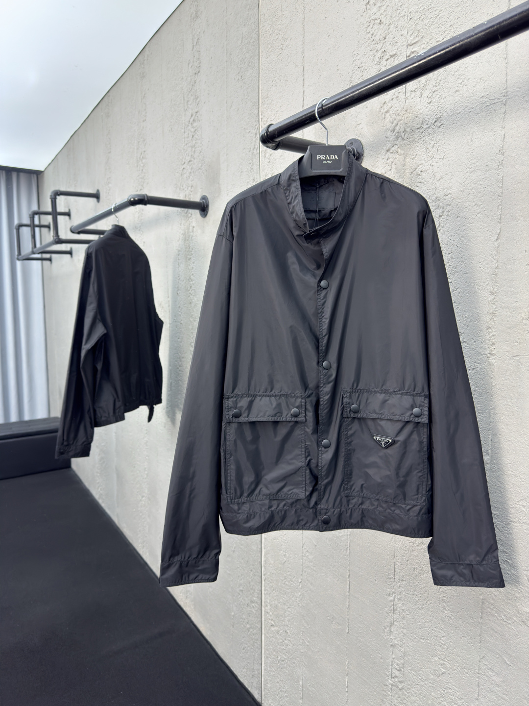 NO:954742,,PRADA regenerated nylon triangle logo jacket  Process description: The stand-up collar structure is adopted to fit the neck line, taking into account the windproof function and smart temperament. The two sides are equipped with extra large-capacity flip pockets to enhance the practicality with a three-dimensional structure. The inner hidden pocket design enhances the private storage experience. The lid and bag body are wrapped and reinforced with double-needle stitching technology, and are coated with enamel.  The enamel triangle logo is decorated on one side of the bag to enhance visual recognition. The combination of cuff straps and concealed buttons achieves precise elasticity requirements. The straight hem structure at the front of the hem and the flat rib closing at the rear make it both beautiful and practical. The overall routing is straight and delicate, the fabric is comfortable and soft, and the color is consistent without color difference.  It can be matched with the same style to create a fashionable look, and can be used in various occasions. Customized accessories, complete with three standards, same style for men and women!  Color Black SizeM~3XL,,prada,jackets & coats,jackets & coats,19860909,PRADA 再生尼龙三角标夹克外套 工艺说明采用立领结构,贴合颈部线条,兼顾防风功能和干练气质.两侧搭配超大容量翻盖口袋,以立体结构强化实用性,内层暗袋设计提升私密收纳体验,盖体和袋体均用双针车线工艺进行包边加固,将涂珐琅三角标饰以一侧袋体之上,强化视觉辨识度.袖口袢带与暗扣的组合实现精准松紧需求,下摆正面平直底边结构与后方的扁牛筋收口让其兼顾美感和实用性.整体走线平直细腻,面料舒适柔软,颜色一致无色差 能与同款搭配营造时尚造型,驾驭各种场合,定制辅料,三标齐全,男女同款！ 颜色黑色 SizeM~3XL,,prada,jackets & coats,jackets & coats,,Men's clothing