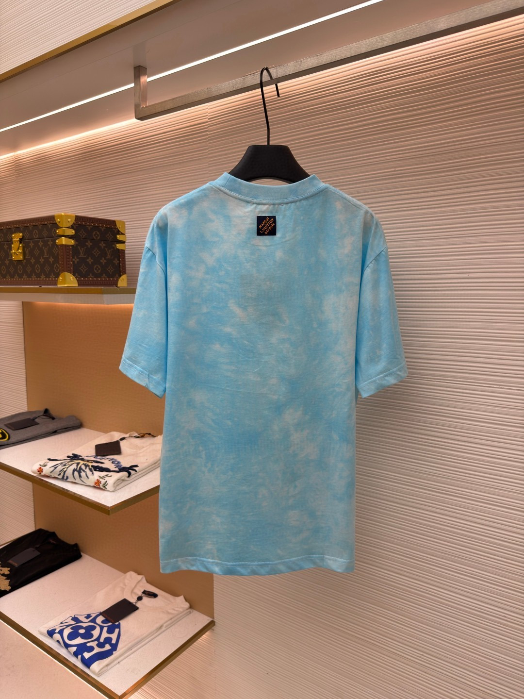 P135 LOUIS VUITTON 云朵扎染圆领短袖
●原版：8500购入开发
●货号：1682621-A10
●面料：平纹针织面料
●工艺：扎染漂白制作
●颜色：蓝白
●版型：合身版型
●克重：约195克
●尺码：XS-S-M-L
●描述：主体采用24S特纺紧密棉打造平纹针织面料，克重185g/㎡。高支数的精梳棉纱通过紧密纺工艺消除了大部分来短毛羽，使得纱线更光滑、强韧。织成的面料结构异常密实、平整且柔软，具有出色的抗起球能力和耐用性，同时保留了纯棉透气亲肤的天然优势。领口则选用32S 1x1罗纹 克重300g，更细的纱支编织出更细腻紧密的螺纹，提供了优于普通罗纹的回弹性与抗变形能力，确保领口历经多次穿脱后仍能保持挺括。通过模仿传统手工艺的现通过捆扎、缝纫或夹板等方式对成衣或面料进行物理防染，然后进行染色。被捆扎的部分染料无法渗入，从而形成独特、不规则且每件都不重复的晕染纹理和图案。通过可控的化学漂洗或酶洗工艺，模拟阳光长期照射后产生的局部褪色效果，形成柔和、自然的色彩层次。这两种工艺共同作用，使每件T恤都拥有独一无二的别致观感，奠定了单品艺术化和手工感的基调。整体走线平直细腻，面料舒适柔软，颜色一致无色差 能与同款搭配营造时尚造型，驾驭各种场合，定制辅料，三标齐全，男女同款！