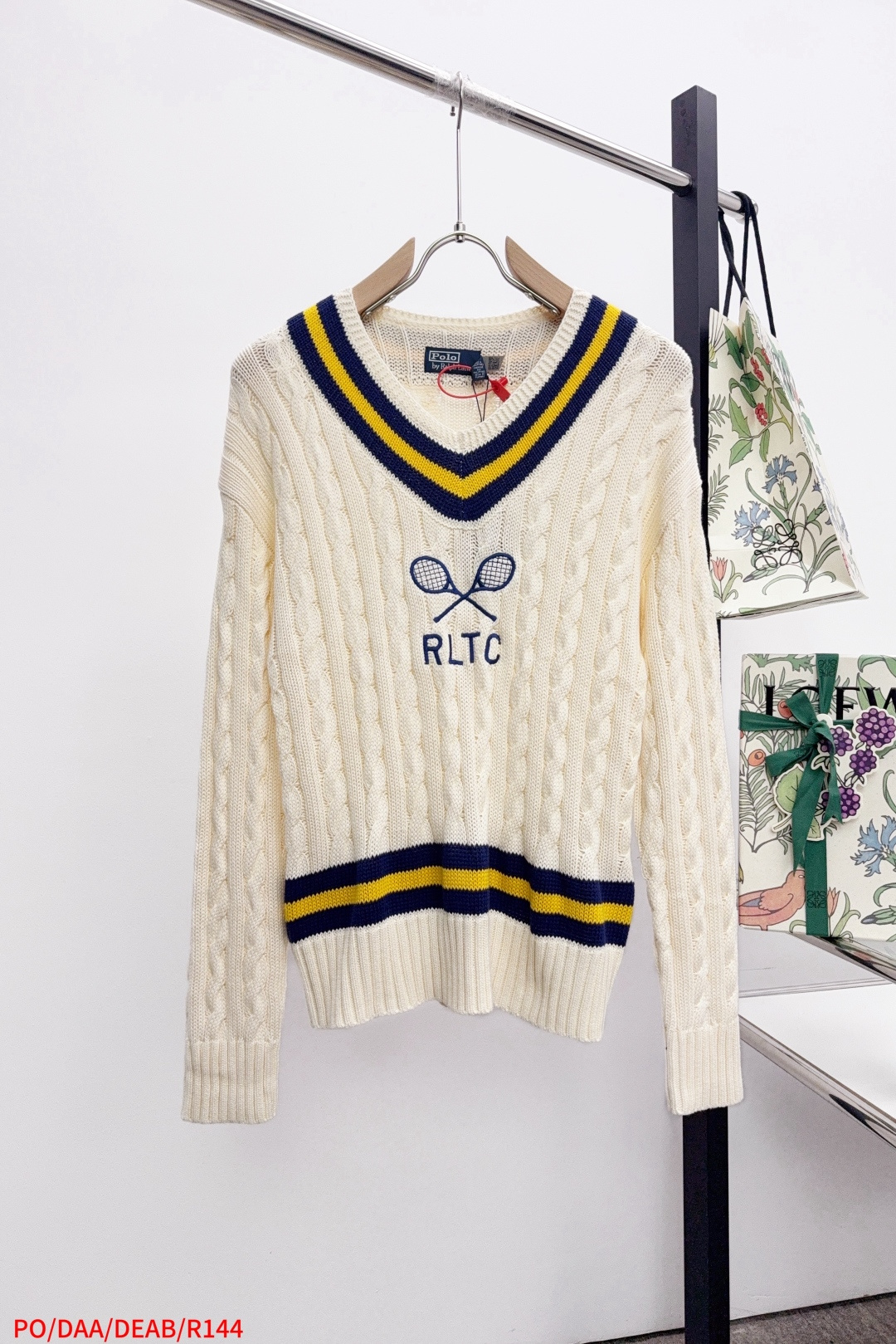 NO:596391,R144 PO Ralph Lauren Tennis Cable Knitted Sweater, made of custom-woven cable knitted thick wool. It has a fine texture and is comfortable and close to the skin. It is mainly in soft cream color. It is pure and warm, with a hint of sweet laziness. The classic cable knitted structure design injects soul. The V-neck is cleverly designed. The edge is outlined with navy blue and bright yellow stripes, which highlights the nobility and extraordinary. The crossed tennis racket pattern and RLTC lettering on the chest are a clever tribute to the brand's sports spirit.  With a breath of freedom and vitality, it is highly recognizable. It interprets high-end style with unique details. It paints an enchanting artistic picture, using imported machine embroidery technology. It uses advanced computer control systems and precision mechanical components to realize the embroidery work of tennis racket patterns and RLTC words with high precision. The lines are smooth and delicate, and the three-dimensional cable weaving is fine. Through the clever shifting and interweaving of coils, adjacent coils are cross-shifted to form a twisting effect of cable. The lines are smooth and regular.  Time-consuming and labor-intensive, the process of adding softness and deodorization to garment washing water uses professional washing equipment and specific detergents to deeply clean and deodorize the clothes to improve the feel and appearance of the clothes. The overall wiring is straight and delicate, the fabric is comfortable and soft, and the color is consistent without color difference. It can be matched with the same style to create a fashionable look and control various occasions. Customized accessories, the same style for men and women!  Sizes S-XL are available in all three sizes. Next day, loro piana, sweaters, alexander wang19860909R144 PO Ralph Lauren 网球绞花编结针织毛衣,定织绞纹厚织羊毛料 纹理细腻 舒适贴肤 以柔和的奶油色为主色调 纯净而温润 带着一丝甜美的慵懒感 经典的绞花编结结构设计注入灵魂 V领巧妙设计 以藏青与明黄条纹勾勒边缘 彰显出高贵与不凡 胸前交叉的网球拍图案与RLTC字样 是品牌对运动精神的巧妙致敬 带着自由与活力的气息 辨识度十足 以独到细节诠释高端格调 绘就了一幅令人心醉神迷的艺术画卷,采用进口机刺绣工艺 使用先进的计算机控制系统和精密的机械部件 实现网球拍图案与RLTC字样刺绣作业 精度高 线条流畅而细腻,立体绞花精织 通过对线圈的巧妙移位和交织 将相邻的线圈进行交叉移位 形成绞花的扭曲效果 线条流畅规整 耗时费力,成衣洗水加软去味工艺 通过专业的洗涤设备和特定的洗涤剂 对衣物进行深度清洁和去味处理改善衣物的手感和外观.整体走线平直细腻,面料舒适柔软,颜色一致无色差 能与同款搭配营造时尚造型,驾驭各种场合,定制辅料,男女同款！尺码S-XL 三标齐全 隔天,,loro piana,sweaters,alexander wang,Men's clothing