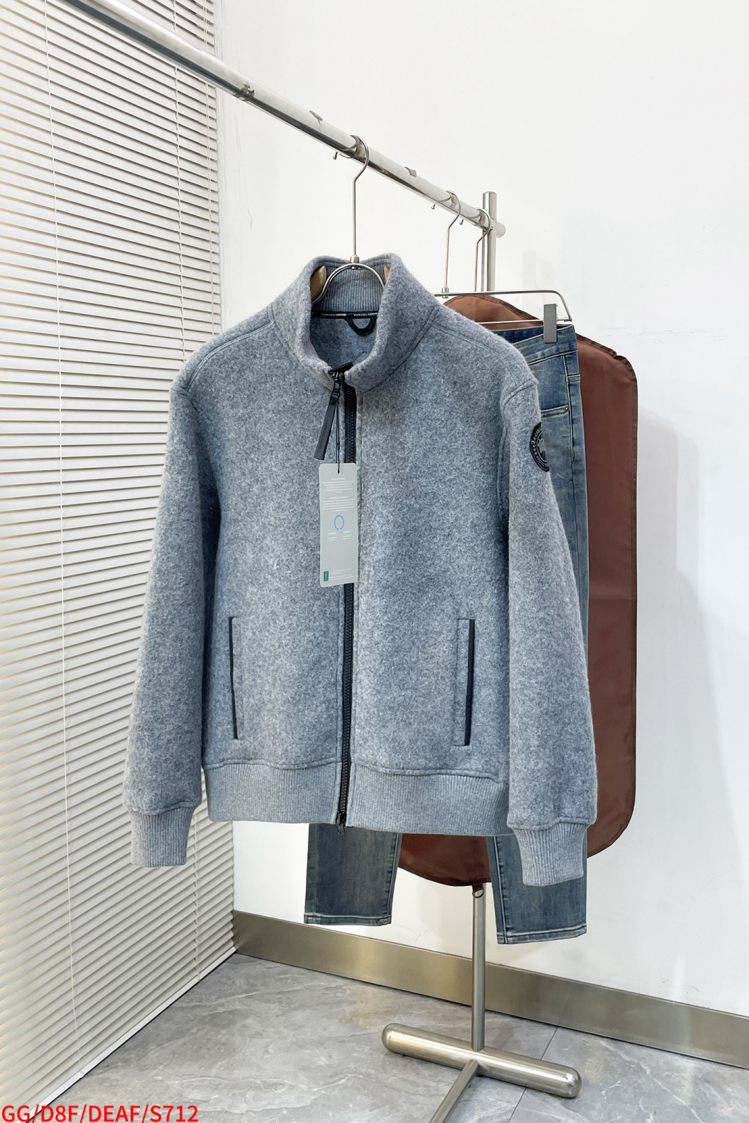 NO:732803,S712 GG Canada Goose fleece emblem stand collar jacket fabric selection  Wool fleece fabric is made of wool as the main body and blended with a very small amount of spandex and polyester fiber. Wool, as the core natural ingredient, provides unparalleled temperature regulation, antibacterial, deodorant, and skin-friendly feel. A small amount of spandex is fed to give the fabric a certain four-way elasticity, and there is no sense of restraint during daily activities. As the basis of the fleece structure, polyester fiber enhances the durability, wrinkle resistance, and quick-drying properties of the fabric. It constitutes the fluffy feel of the fleece and provides functions such as locking in air. Details  The sleeves and hem are closed with 2×2 ribbing. Its strong elasticity can closely fit wrists and waists of different thicknesses, forming an effective 'seal' to prevent cold wind from blowing back. It can still maintain its original shape after repeated stretching and use, and is not easy to loose and deform. The ribbed cuffs can convey a sense of design and enhance visual beauty. Production process The cutting process needs to ensure that the texture and color of the fabric are evenly distributed, especially for this light gray tone, color difference needs to be avoided.  When cutting pieces, you need to consider the stretchability of wool blended fabrics to ensure the size of the garment is stable. Use sewing needles and threads suitable for wool blended fabrics to avoid damage to the fabric during the sewing process. Sewing stitches should be even and firm to prevent thread detachment. The temperature needs to be controlled when ironing to avoid damage to the fabric due to high temperatures, while keeping the fabric flat and stiff. Armband The circular armband on the left arm is an important part of the brand logo, and is finely sewn to ensure firmness and smoothness. Sizes S-XL  Three standard items available, next day, jackets & coats,19860909S712 GG Canada Goose 抓绒饰章立领版外套 面料选择 以羊毛为主体,加入极少量氨纶和聚酯纤维混纺而成的羊毛抓绒面料.羊毛作为核心天然成分,提供无与伦比的温度调节、抑菌防臭和亲肤感.少量氨纶的喂入赋予了面料一定的四向弹性,日常活动时毫无束缚感.作为抓绒结构的基础,聚酯纤维增强了面料的耐久性、抗皱性和快干性,它构成了抓绒的蓬松感,并提供锁住空气等功能. 细节 衣袖和下摆采用2乘2罗纹收口,其强大的弹性,可以紧密贴合不同粗细的手腕和腰部,形成一个有效的‘密封’,防止冷风倒灌.在多次拉伸和使用后仍能保持原有形状,不易松垮变形.且罗纹袖口能传递一种设计感,强化视觉美观度. 生产工艺 裁剪过程需确保面料的纹理和颜色均匀分布,特别是对于这种浅灰色调,需避免色差. 裁片时需考虑羊毛混纺面料的伸缩性,确保成衣尺寸稳定.  使用适合羊毛混纺面料的缝纫针和线,避免面料在缝制过程中受损. 缝制线迹均匀、牢固,防止脱线.  整烫时需控制温度,避免高温对面料造成损伤,同时保持面料的平整和挺括. 臂章 左臂上的圆形臂章是品牌标识的重要部分,精细缝制,确保牢固且平整. 尺码S-XL 三标齐全 隔天,,jackets & coats,,Men's clothing