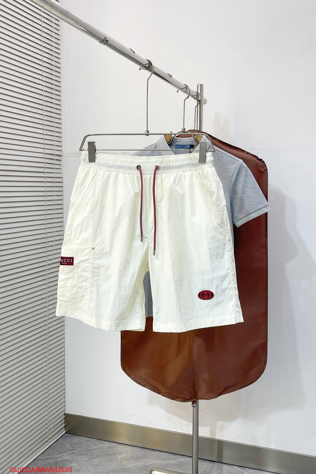 NO:838504,U530 GUCCI Gucci  2026ss summer contrast drawstring casual shorts, available in black, rice and white, use the brand's iconic burgundy contrast color to reconstruct summer casual aesthetics. Made of high-density wrinkled nylon fabric, with lightweight and breathable texture, the upper body is draped and stylish, without fear of stuffiness and wrinkles; the waistband is designed with burgundy contrast drawstring,  It is matched with the brand logo details of the same color to inject brand vitality at a glance. The three-dimensional work patch pockets on the side are equipped with metal buckles, the front oval logo and the back webbing logo strictly echo, and the neat straight version modifies the leg shape. Whether it is urban commuting or vacation travel, it can easily interpret the relaxed and distinguished high-end texture.  Size M-3XL,,gucci,shorts,19860909U530 GUCCI 古奇 2026ss夏季撞色抽绳休闲短裤,黑米白双色可选,以品牌标志性酒红撞色重构夏日休闲美学.甄选高密皱感尼龙面料打造,自带轻量透气肌理,上身垂坠有型,无惧闷热与褶皱；腰头酒红撞色抽绳设计,搭配同色系品牌标识细节,一眼注入品牌活力.侧面立体工装贴袋搭配金属扣,正面椭圆标与背面织带标严谨呼应,利落直筒版型修饰腿型,无论是都市通勤还是度假出行,皆能轻松演绎松弛显贵的高阶质感. 码数M-3XL,,gucci,shorts,,Men's clothing