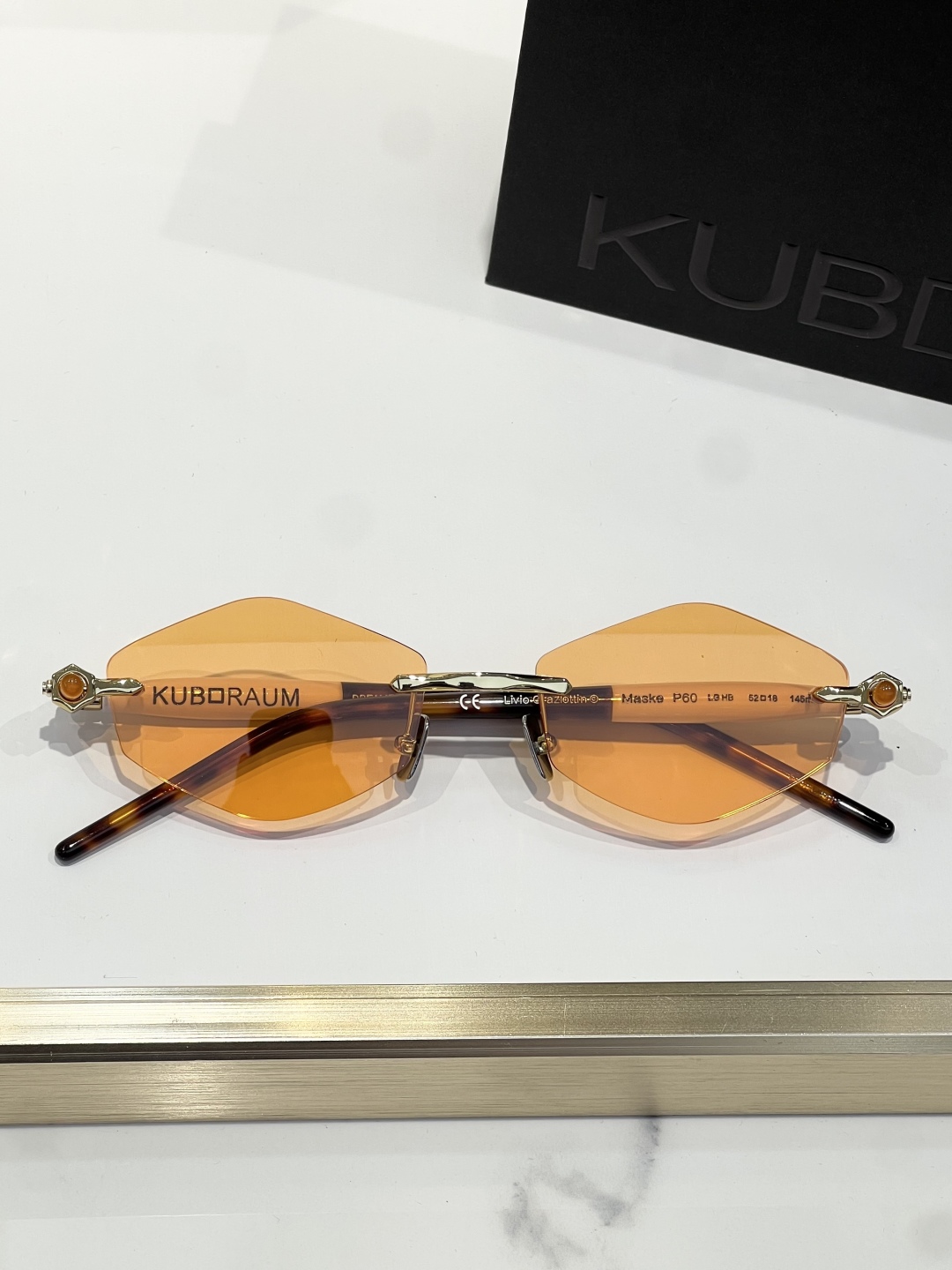 
KUBORAUM 经典无框太阳镜，精致优雅。金属与浅哈瓦那棕色醋酸纤维的完美融合。镜框采用圆形设计，搭