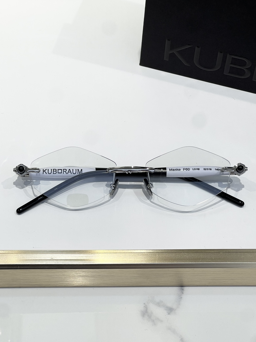 
KUBORAUM 经典无框太阳镜，精致优雅。金属与浅哈瓦那棕色醋酸纤维的完美融合。镜框采用圆形设计，搭