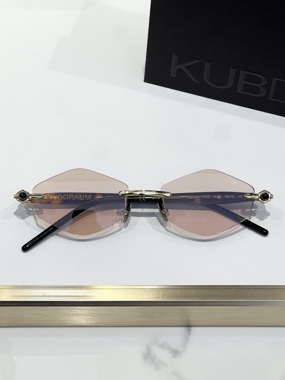 
KUBORAUM 经典无框太阳镜，精致优雅。金属与浅哈瓦那棕色醋酸纤维的完美融合。镜框采用圆形设计，搭