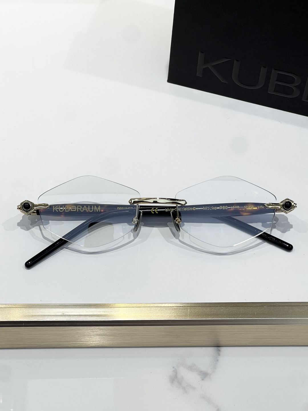 
KUBORAUM 经典无框太阳镜，精致优雅。金属与浅哈瓦那棕色醋酸纤维的完美融合。镜框采用圆形设计，搭