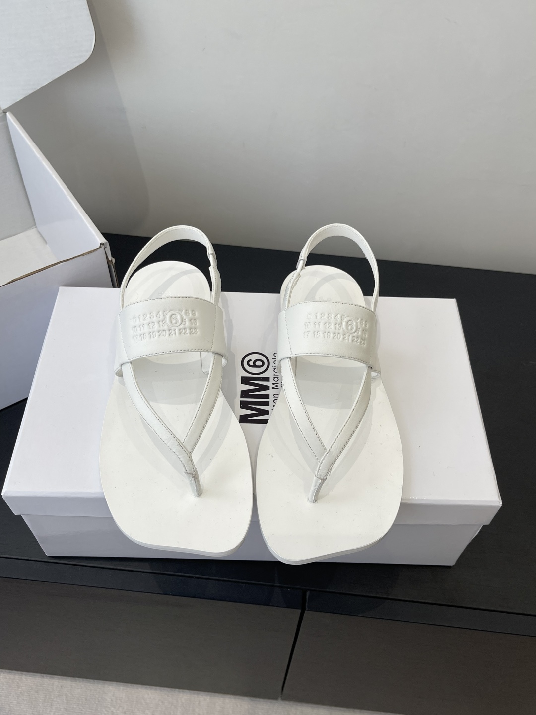 NO:722137,Maison Margiela MM6 Margiela 26ss new spring and summer flip-flops sandals break the rounded shape of traditional flip-flops and adopt a square toe + clip feet + back strap design. The back strap is adjustable and takes into account both comfort and wrapping; minimalist lines and geometric square toe create a pioneering deconstruction style, suitable for daily casual, street fashion and other scenes. The MM6 Maison Margiela brand letter logo is embossed on the ankle strap.  The inside of the shoe box is printed with the brand's classic MM6 logo and the full name of the brand. The low-key embossing process is in line with the brand's minimalist and deconstructed design tonality and strengthens brand recognition. Sheepskin upper, sheepskin lining, genuine leather outsole, size 35-40 (customized for 40), split-toe shoes, masion margiela, masion margiela, sandals, sheepskin, Leather soles19860909Maison Margiela MM6 马吉拉 26ss春夏新款 人字拖 凉鞋 打破传统人字拖的圆润版型 采用方头+夹脚+后绊带设计 后绊带可调节 兼顾舒适度与包裹性；极简的线条搭配几何感方头 打造出先锋的解构主义风格,适配日常休闲、街头潮搭等场景  脚踝绊带处压印MM6 Maison Margiela品牌字母标识 鞋盒内侧印有品牌经典的MM6 logo与品牌全称 低调的压印工艺契合品牌极简、解构的设计调性 强化品牌辨识度 鞋面羊皮 内里羊皮 真皮大底 码数35-40（40定做）,分趾鞋,masion margiela,masion margiela,sandals,sheepskin,Leather soles,Women's Shoes