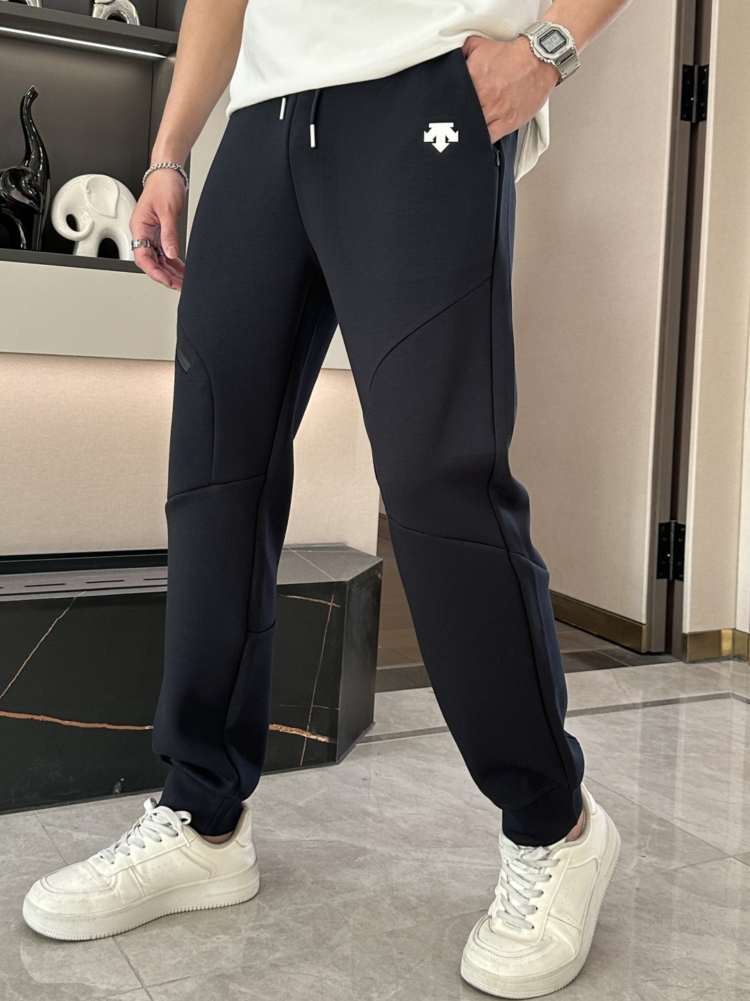 NO:132937,Desant Black sports trousers are a model of fashion and function. The deep black is mysterious and versatile, exuding a low-key cool feeling, which can be easily adapted for sports and fitness or daily travel. The drawstring design at the waist can flexibly adjust the elasticity and tightness to ensure a comfortable fit. The three-dimensional tailoring and splicing technology is unique and smooth and natural, not only shaping a neat appearance, but also in line with ergonomics and convenient for sports and stretching. The design of multiple pockets is practical and beautiful. The zippered pocket can safely store small objects, and the side pockets are convenient for placing items at will. The exquisite brand logo on one side of the trouser body shows quality and style in a low-key manner.  The fabric is soft and elastic, comfortable and comfortable to wear, with good breathability and wear resistance. The foot design is paired with elastic trouser leg mouth, which is neat and stylish, highlighting the ankle lines, allowing you to show vitality during exercise and show a trendy attitude in daily wear. Size L-XXXL,,alexander wang19860909迪桑特 黑色运动长裤,是时尚与功能兼具的典范.深沉的黑色,神秘而百搭,散发着低调的酷感,无论是运动健身还是日常出行,都能轻松适配. 腰部的抽绳设计,可灵活调节松紧,确保舒适贴合.立体剪裁与拼接工艺独具匠心,线条流畅自然,不仅塑造出利落的外观,更符合人体工学,方便运动伸展.多个口袋设计实用又美观,拉链口袋能安全收纳小物件,侧边口袋方便随手放置物品.裤身一侧精致的品牌标识,低调彰显品质与格调. 面料兼具柔软与弹性,穿着舒适自在,具备良好的透气性和耐磨性.束脚设计搭配弹性裤脚口,利落有型,凸显脚踝线条,让你在运动中尽显活力,于日常穿搭中展现潮流态度. 尺码L-XXXL,,alexander wang,Men's clothing