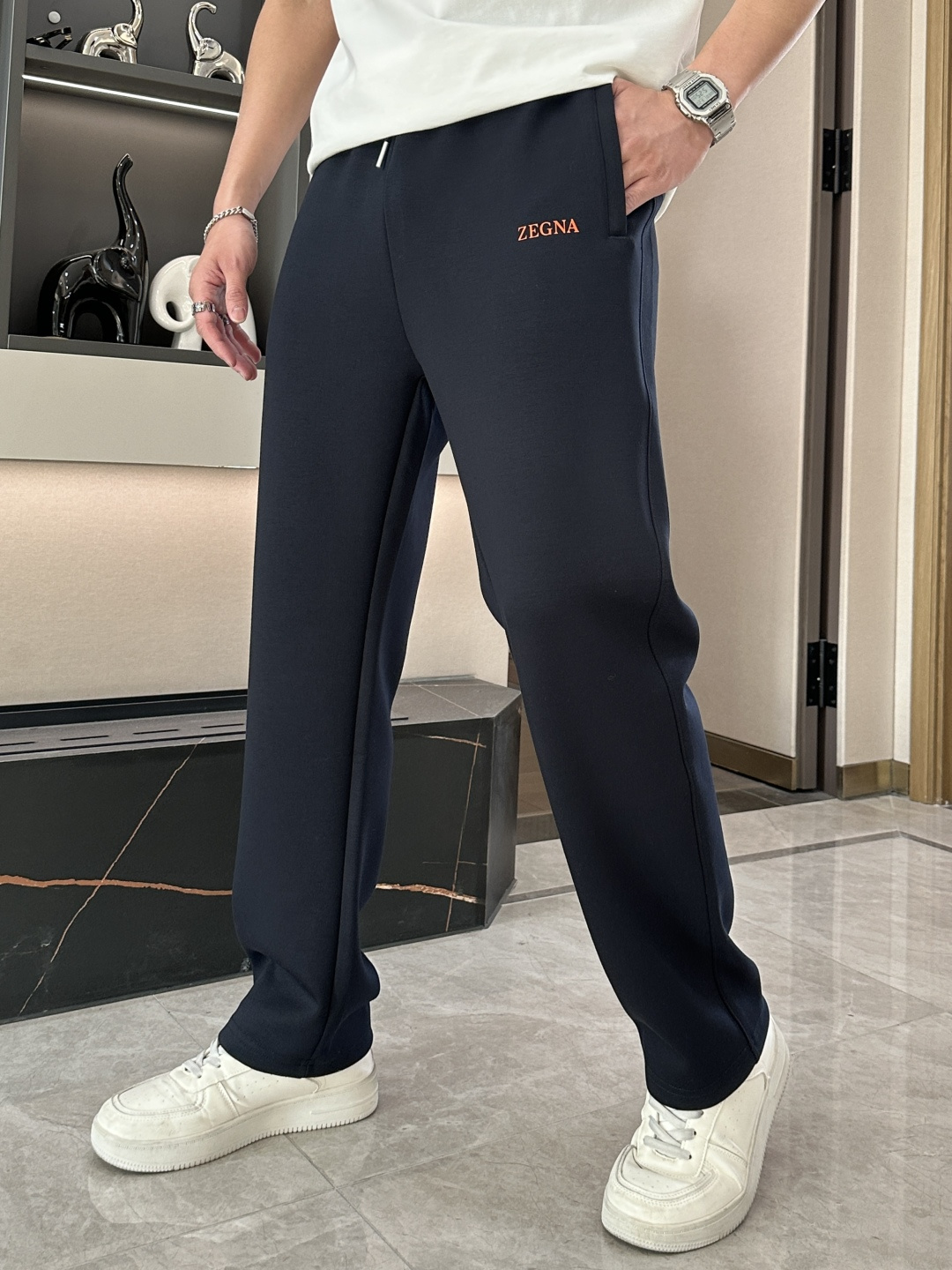 NO:132939,Zegna's dark blue sports trousers show the high-end texture and fashion taste of Zegna's brand. The deep blue is calm and atmospheric, exudes the charm of low-key luxury, and is easily adapted to various occasions. The waist drawstring design can adjust the elasticity as needed to ensure a comfortable fit. The simple and smooth lines outline the neat pattern, modify the leg lines, and show a capable posture. The pockets on both sides are practical and beautiful, making it convenient to place personal belongings. The eye-catching orange 