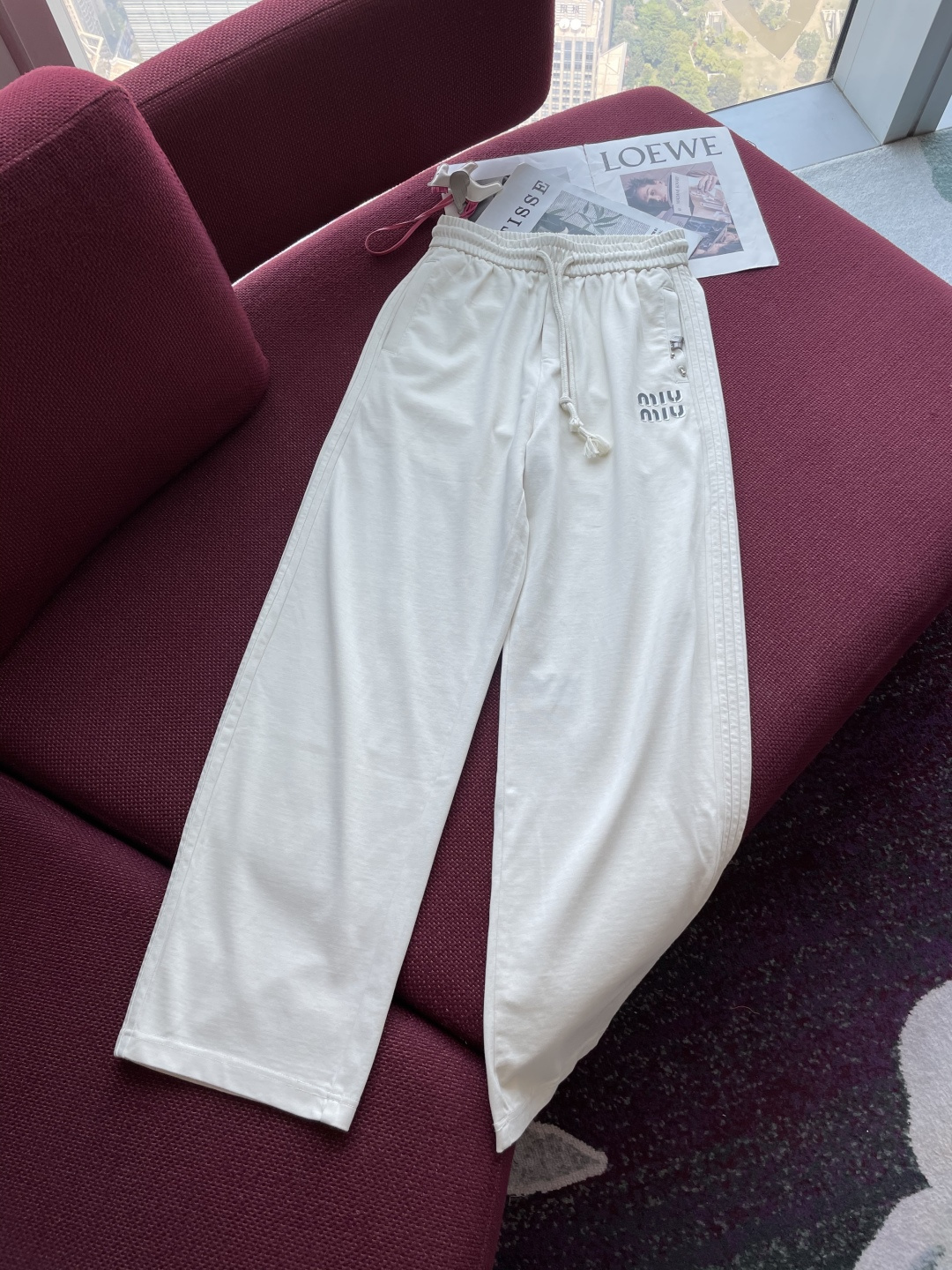 NO:132928,Miumiu's white casual trousers show the beauty of simplicity and elegance. Pure white, like the early snow in spring, exudes a fresh and soft atmosphere, conveying a lazy and stylish sense of style. The waist drawstring design can be freely adjusted, which not only ensures a comfortable fit for wear, but also adds a bit of casualness. The straight-tube style is neat and elegant, and the naturally draped lines can well modify the outline of the legs and create a simple and atmospheric visual effect. The exquisite brand letters on the sides show the brand's characteristics and personality charm. The fabric is soft and skin-friendly, with good breathability, and comfortable wearing experience. Whether it is a simple solid-color top to create a casual and daily style, or a combination with a delicate sweater to attend a light social occasion, it can be easily controlled, helping you interpret the lazy and fashionable aesthetics of the modern city with an elegant posture.  Size M-XXL, miumiu,alexander wang19860909miumiu 这条白色休闲长裤,尽显简约与优雅的融合之美.纯净的白色,如春日初雪,散发着清新、柔和的气息,传递出一种慵懒又不失格调的时尚感. 腰部抽绳设计,可自由调节松紧,既保证穿着的舒适贴合,又增添几分随性.直筒版型利落大方,自然垂坠的线条,能很好地修饰腿部轮廓,营造出简约大气的视觉效果.侧边精致的品牌字母,低调彰显品牌特色与个性魅力. 面料柔软亲肤,透气性佳,穿着体验舒适.无论是搭配简约的纯色上衣打造休闲日常风,还是与精致的针织衫组合出席轻社交场合,它都能轻松驾驭,助你以优雅姿态诠释现代都市的慵懒时尚美学. 尺码M-XXL,,miumiu,alexander wang,Men's clothing
