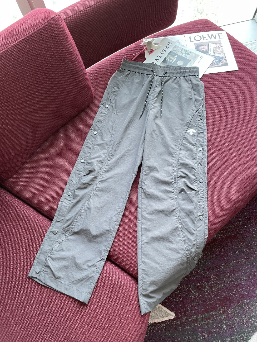 NO:132932,Desante This light gray trousers perfectly combine functional elements with trendy design. The low-key light gray is simple and yet textured, laying a versatile foundation for the overall look. The waist drawstring design can flexibly adjust elasticity and bring a comfortable wearing experience. The unique breasted decoration on both sides of the trouser body breaks the convention and adds personality and fashion sense. At the same time, the trouser leg shape can be adjusted as needed to meet the diverse dressing needs. The exquisite brand logo is low-key embellishment to highlight quality and style. The fabric is light and durable, suitable for daily activities. Whether it is a simple T-shirt to create a casual street style or a functional top to show the outdoor trend, it can be easily controlled, helping you stand out from the crowd and interpret the fashion aesthetics of both trend and practicality with a unique posture. Size M-XXXL,,tees, t-shirt, alexander wang19860909迪桑特 这条浅灰色长裤,将机能元素与潮流设计完美融合.低调的浅灰色,简约又不失质感,为整体造型奠定百搭基础. 腰部抽绳设计,可灵活调节松紧,带来舒适穿着体验.裤身两侧独特的排扣装饰,打破常规,增添个性与时尚感,同时可按需调整裤腿造型,满足多样穿搭需求.精致的品牌标识低调点缀,彰显品质与格调. 面料兼具轻便与耐用性,适合日常活动.无论是搭配简约T恤打造休闲街头风,还是与机能风上衣组合,展现户外潮流感,它都能轻松驾驭,助你在人群中脱颖而出,以独特姿态诠释潮流与实用兼具的穿搭美学. 尺码M-XXXL,,tees，t-shirt,alexander wang,Men's clothing