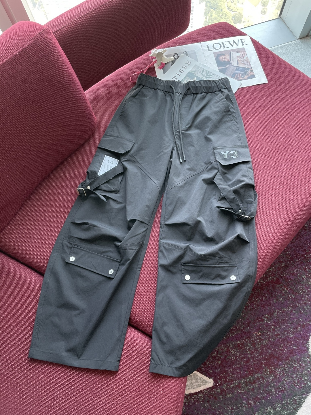 NO:132940,Y-3 black work pants show the unique trend and functional style of the Y-3 brand. The classic black is mysterious and versatile, and can easily integrate into various outfit scenes, which are suitable for street walks or sports travel. The waist drawstring design allows flexible adjustment of elasticity to ensure a comfortable fit. The trousers are covered with multiple functional pockets, paired with metal buttons, snaps and webbing details. It not only has the characteristics of tool style, but also provides sufficient storage space to carry items. The exquisite 