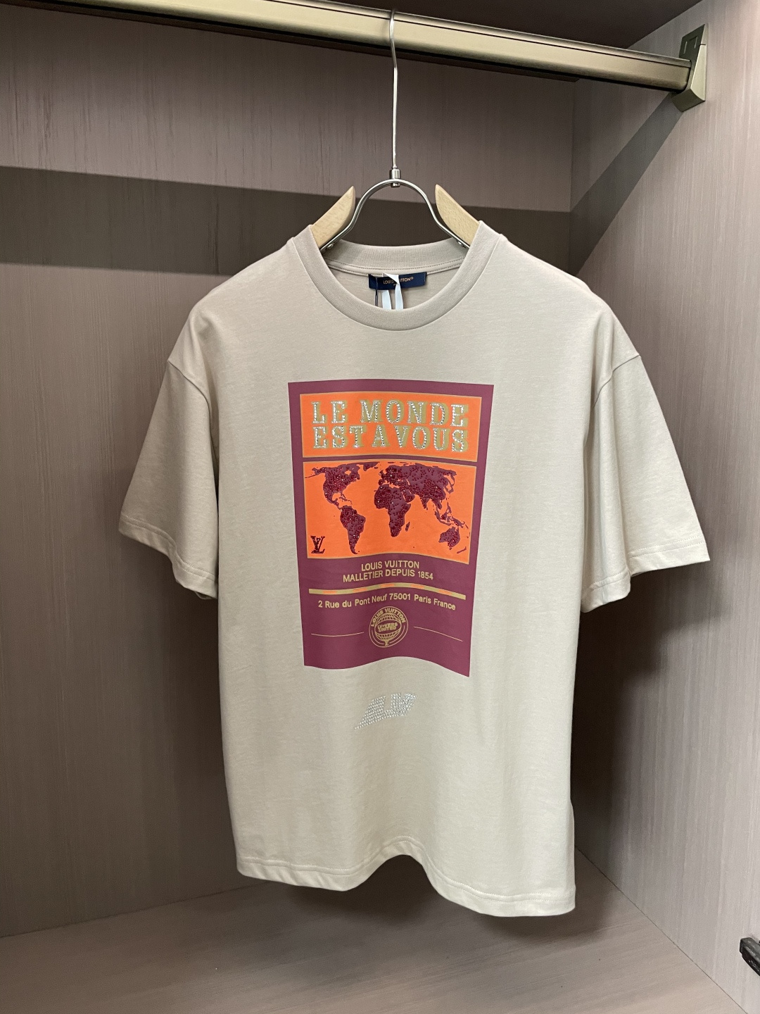 NO:135133,This Louis Vuitton beige T-shirt cleverly blends the luxury of the brand with a global vision. The soft beige is simple but not lacking in style, creating a warm and high-end atmosphere. The large pattern on the front is eye-catching, and the words 