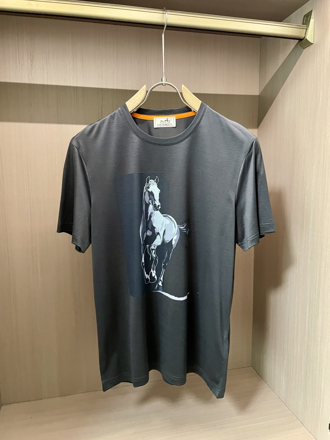 NO:443289,Aes new product. The classic round neck design is simple and elegant, fits the neck lines, and is comfortable and comfortable to wear, suitable for various casual occasions. The pattern on the front of the T-shirt is a horse, which outlines the galloping posture of the horse with simple and vivid lines, which is lifelike, showing vitality and dynamic. As the iconic element of the Hermes brand, the horse not only symbolizes the brand's exquisite craftsmanship and long history, but also gives this T-shirt a unique soul and charm. In terms of fabric, Hermes continues its consistent pursuit of high quality, with soft texture, good skin-friendly, good breathability, comfortable wearing, and has good elasticity and drape, ensuring the style of the clothes is crisp. This T-shirt perfectly combines Hermes' classic elements with fashionable design, and is an excellent item to show elegant taste and vitality attitude.  Austrian imported Lanjing Tensacca, the feel is super good, the touch is softer and smoother than ordinary mercerized cotton, and it is more refreshing and comfortable to wear, and it will not fade and not deform after wearing for a long time. Size M-3XL (model 172 cm 148 catties and try on L size is suitable), hermes,tees, t-shirt,alexander wang19860909爱仕 新品 经典圆领设计,简约大方,贴合颈部线条,穿着舒适自在,适配各种休闲场合. T恤正面的图案是一匹骏马,以简洁而生动的线条勾勒出骏马奔腾的姿态,栩栩如生,尽显活力与动感.骏马作为爱马仕品牌的标志性元素,不仅象征着品牌的精湛工艺与悠久历史,更赋予这件T恤独特的灵魂与魅力. 在面料上,爱马仕延续一贯的高品质追求,质地柔软亲肤,透气性佳,穿着体感舒适,同时具备良好的弹性与垂坠感,确保衣物的版型挺括.这款T恤将爱马仕的经典元素与时尚设计完美融合,是展现优雅品味与活力态度的绝佳单品. 面料奥地利进口兰精天丝兰,手感超级赞,摸上去比一般丝光棉更加柔软顺滑,穿着更加冰爽舒适,且久穿久洗不褪色不变形.尺码M-3XL（模特172厘米148斤试穿L码合适）,,hermes,tees，t-shirt,alexander wang,Men's clothing