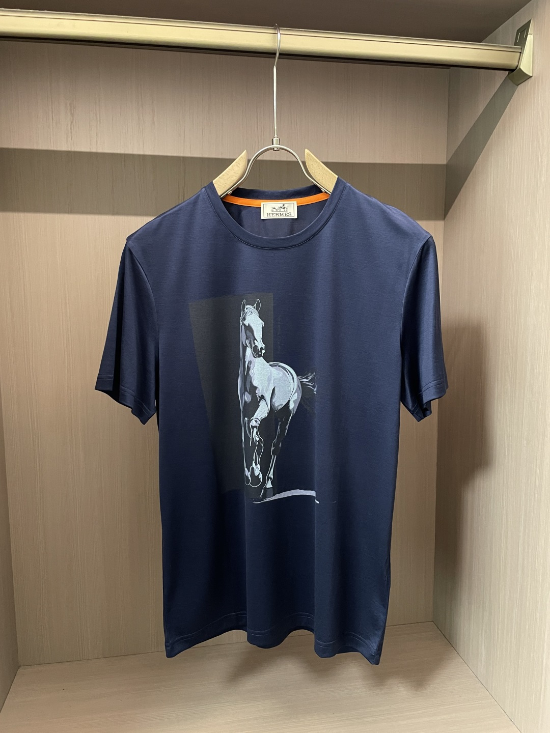 NO:443293,Aes new product. The classic round neck design is simple and elegant, fits the neck lines, and is comfortable and comfortable to wear, suitable for various casual occasions. The pattern on the front of the T-shirt is a horse, which outlines the galloping posture of the horse with simple and vivid lines, which is lifelike, showing vitality and dynamic. As the iconic element of the Hermes brand, the horse not only symbolizes the brand's exquisite craftsmanship and long history, but also gives this T-shirt a unique soul and charm. In terms of fabric, Hermes continues its consistent pursuit of high quality, with soft texture, good skin-friendly, good breathability, comfortable wearing, and has good elasticity and drape, ensuring the style of the clothes is crisp. This T-shirt perfectly combines Hermes' classic elements with fashionable design, and is an excellent item to show elegant taste and vitality attitude.  Austrian imported Lanjing Tensacca, the feel is super good, the touch is softer and smoother than ordinary mercerized cotton, and it is more refreshing and comfortable to wear, and it will not fade and not deform after wearing for a long time. Size M-3XL (model 172 cm 148 catties and try on L size is suitable), hermes,tees, t-shirt,alexander wang19860909爱仕 新品 经典圆领设计,简约大方,贴合颈部线条,穿着舒适自在,适配各种休闲场合. T恤正面的图案是一匹骏马,以简洁而生动的线条勾勒出骏马奔腾的姿态,栩栩如生,尽显活力与动感.骏马作为爱马仕品牌的标志性元素,不仅象征着品牌的精湛工艺与悠久历史,更赋予这件T恤独特的灵魂与魅力. 在面料上,爱马仕延续一贯的高品质追求,质地柔软亲肤,透气性佳,穿着体感舒适,同时具备良好的弹性与垂坠感,确保衣物的版型挺括.这款T恤将爱马仕的经典元素与时尚设计完美融合,是展现优雅品味与活力态度的绝佳单品. 面料奥地利进口兰精天丝兰,手感超级赞,摸上去比一般丝光棉更加柔软顺滑,穿着更加冰爽舒适,且久穿久洗不褪色不变形.尺码M-3XL（模特172厘米148斤试穿L码合适）,,hermes,tees，t-shirt,alexander wang,Men's clothing