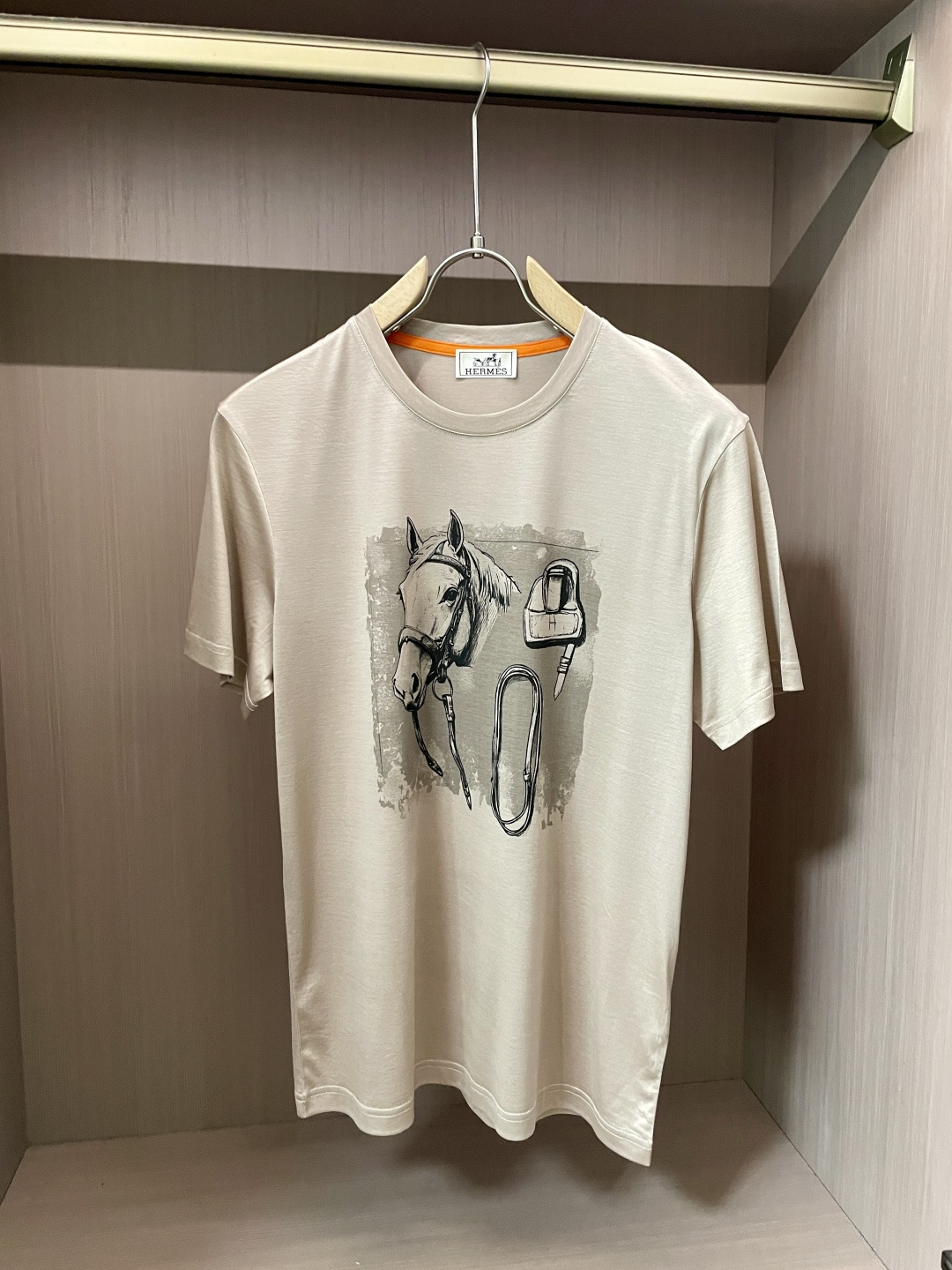 NO:443308,Aess' new product creates a simple and elegant atmosphere with pure and soft tones. The classic round neck design fits the neck lines and shows a neat and generous temperament, which can be easily controlled whether it is daily travel or casual gatherings. The pattern on the front of the T-shirt is its unique charm. It depicts the head of a horse with delicate brushstrokes, and matches the elements of horse harness to vividly show the deep connection between Hermes and horse culture. The unique artistic style of the pattern and the background treatment of the old effect adds retro charm and artistic texture, highlighting Hermes' unique design aesthetics.  In terms of fabric, it continues Hermes' consistent high-quality standards, with soft and skin-friendly texture, excellent breathability, comfortable and comfortable to wear, and has a good drape, ensuring the crisp and beautiful style. This T-shirt perfectly combines Hermes' classic elements with fashionable design, and is an ideal choice for those who pursue quality and personality, showing a luxurious style in the details. The fabric is imported from Austria, with a super touch, and is softer and smoother to the touch than ordinary mercerized cotton, and is more refreshing and comfortable to wear, and it will not fade and not deform after wearing for a long time. Size M-3XL (model 172 cm 148 catties and try on L size), hermes,tees, t-shirt, alexander wang19860909爱仕 新品 以纯净柔和的色调,营造出简约而高雅的氛围.经典圆领设计,贴合颈部线条,展现出利落大方的气质,无论是日常出行还是休闲聚会,都能轻松驾驭. T恤正面的图案是其独特魅力所在,以细腻的笔触描绘出骏马的头部,搭配马具元素,生动展现爱马仕与马文化的深厚渊源.图案的艺术风格独特,做旧效果的背景处理,增添了复古韵味与艺术质感,彰显出爱马仕别具一格的设计美学. 面料上,延续爱马仕一贯的高品质标准,质地柔软亲肤,透气性极佳,穿着舒适自在,同时具备良好的垂坠感,保证了版型的挺括与美观.这款T恤将爱马仕的经典元素与时尚设计完美融合,是追求品质与个性人士的理想之选,于细节处尽显奢华格调. 面料奥地利进口兰精天丝兰,手感超级赞,摸上去比一般丝光棉更加柔软顺滑,穿着更加冰爽舒适,且久穿久洗不褪色不变形.尺码M-3XL（模特172厘米148斤试穿L码合适）,,hermes,tees，t-shirt,alexander wang,Men's clothing