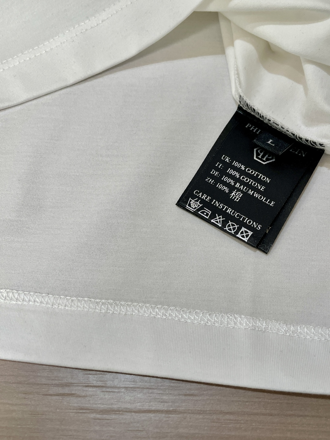 “Philip Planan’s Skull Signature T-Shirt: Custom Fabric, Unique Design, Metal Logo Card” - 图片 7