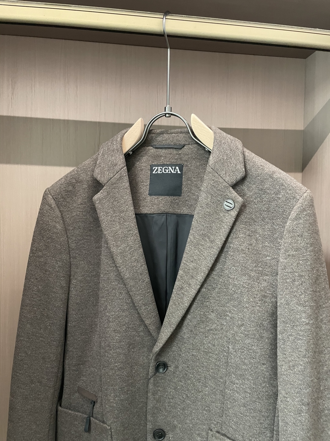 这款杰尼亚羊毛西装，是商务绅士的“质感名片”！精选细腻羊毛面料，浅咖色人字纹肌理自带低调奢华感，在光线里