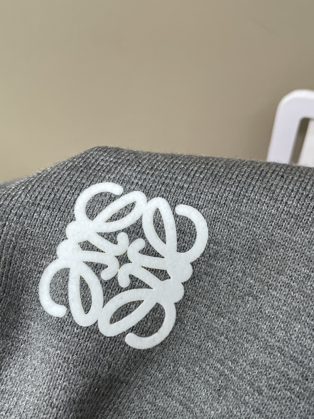 这个LOEWE针织外套 是慵懒与精致的绝妙平衡。自带松弛的氛围感，细腻针织纹理裹着软绵暖意，贴肤时是恰到