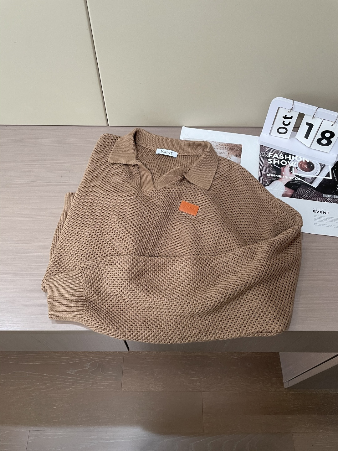 这件LOEWE针织Polo，是把「松弛质感」织进了每一寸纹理里。浅驼色主调像浸了阳光的燕麦，自带温柔的松