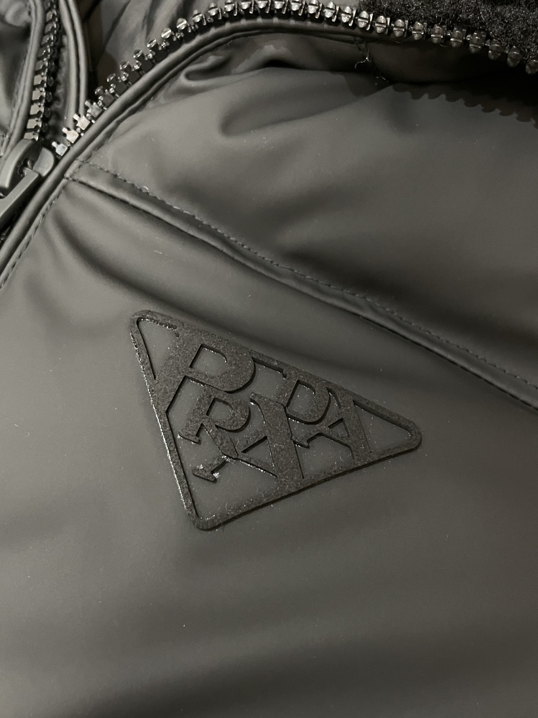 Prada都市轻奢款羊羔毛领羽绒棉棉衣 复古松弛冬日款作为Prada日常线核心款，这件棉衣以“轻奢质感+