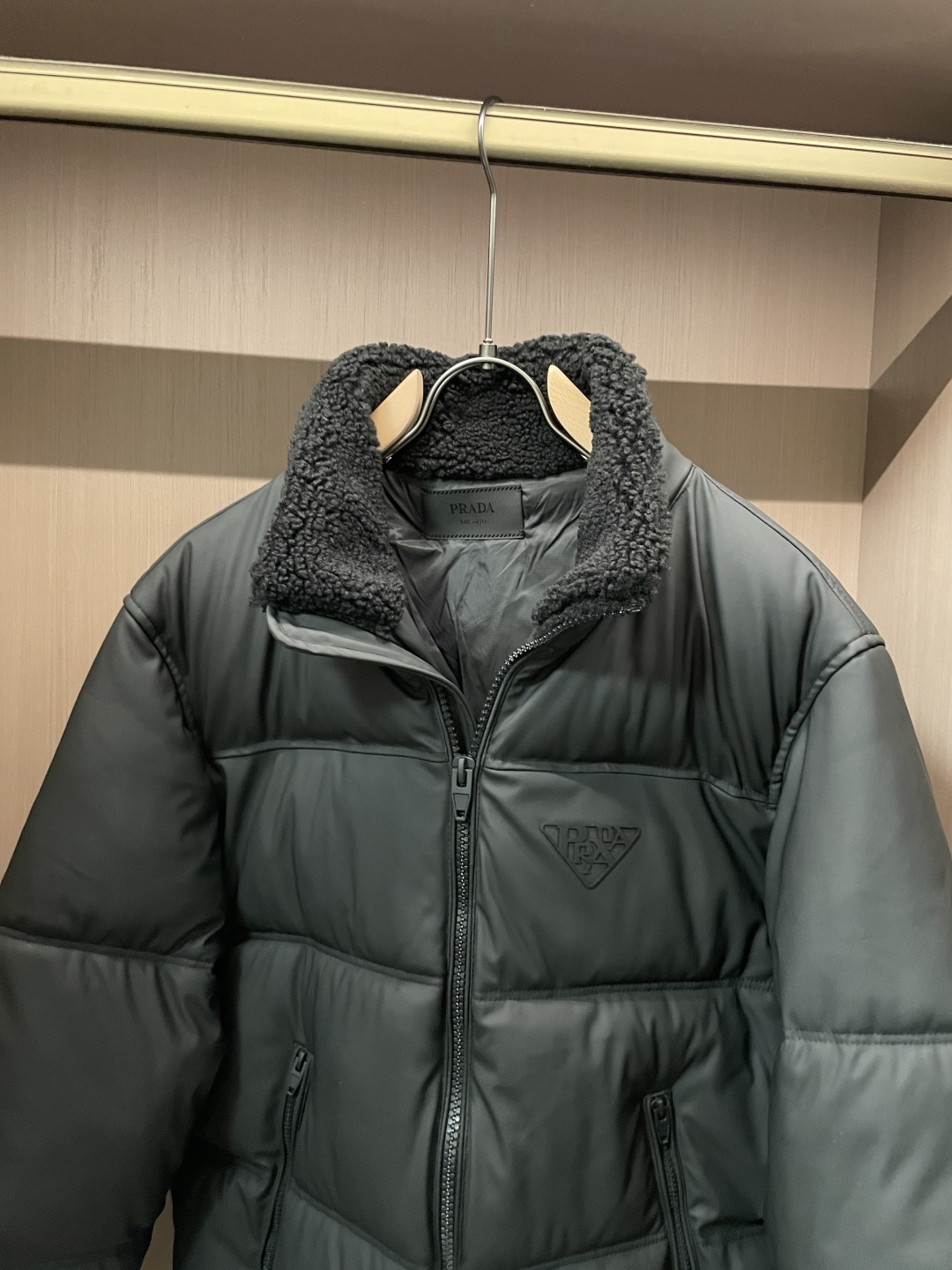 Prada都市轻奢款羊羔毛领羽绒棉棉衣 复古松弛冬日款作为Prada日常线核心款，这件棉衣以“轻奢质感+