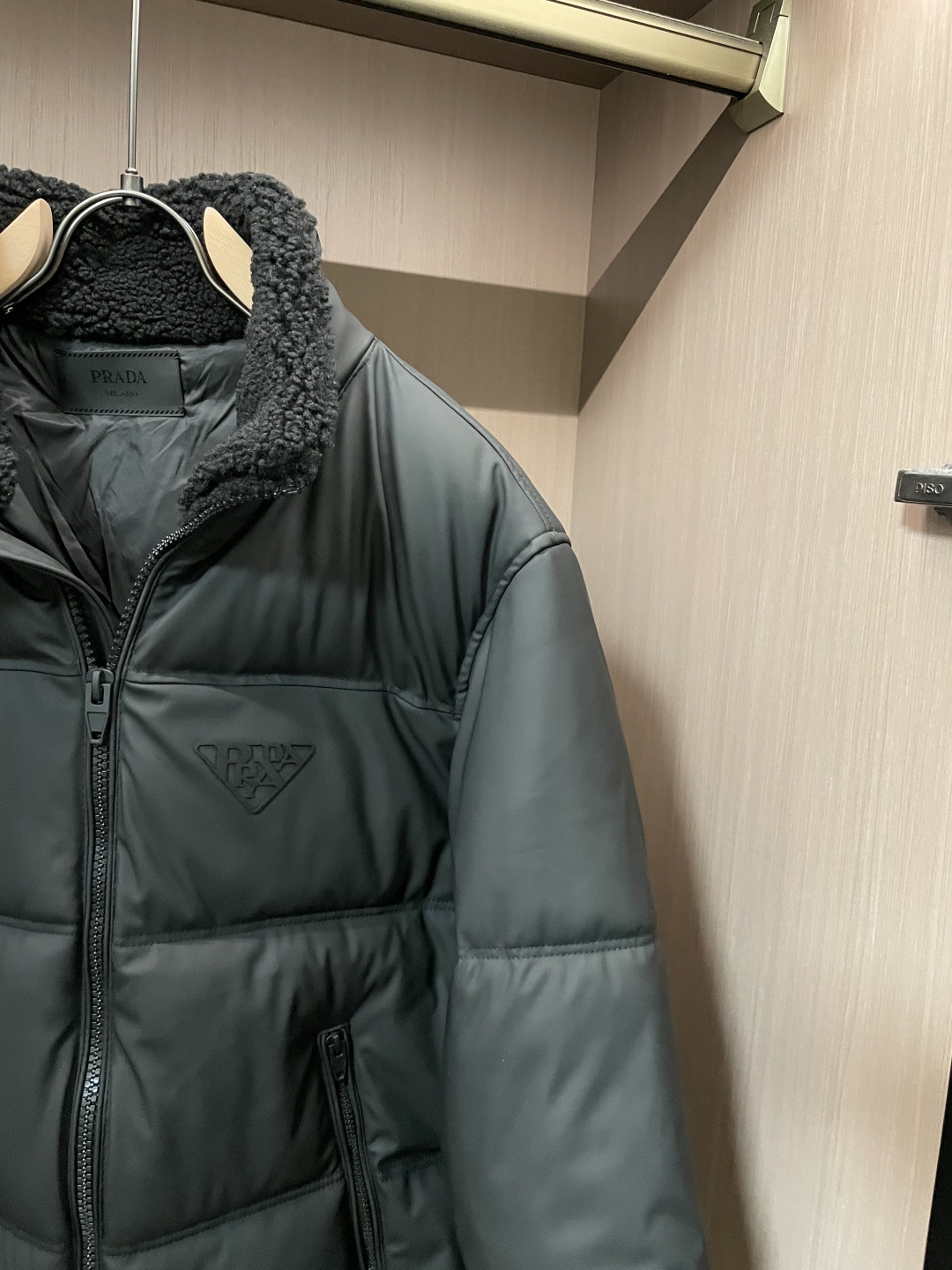 Prada都市轻奢款羊羔毛领羽绒棉棉衣 复古松弛冬日款作为Prada日常线核心款，这件棉衣以“轻奢质感+