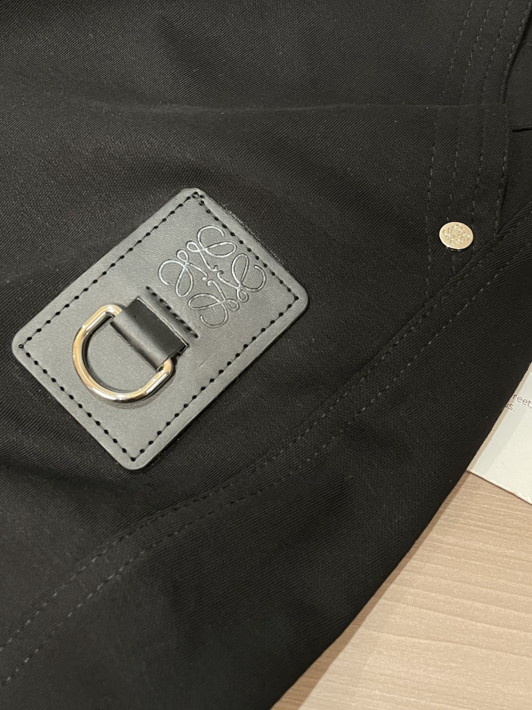 Loewe这条休闲裤，是把“轻奢巧思藏在工装细节里”的款——不是软塌的普通休闲裤，面料带细腻哑光肌理，软