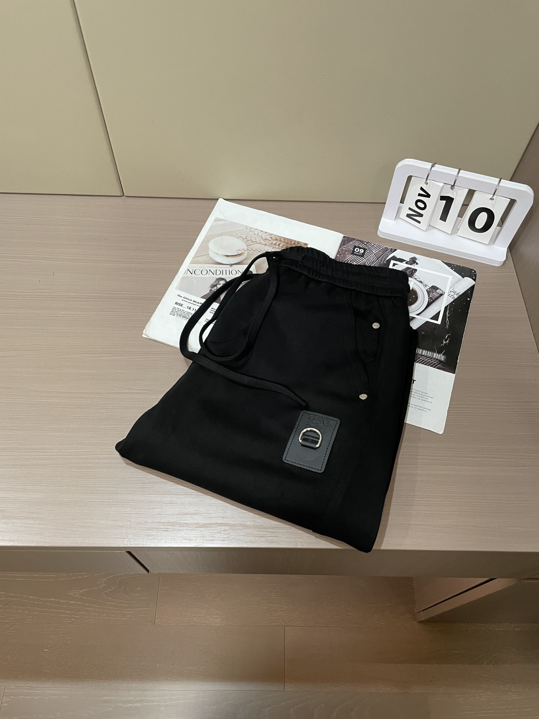 Loewe这条休闲裤，是把“轻奢巧思藏在工装细节里”的款——不是软塌的普通休闲裤，面料带细腻哑光肌理，软