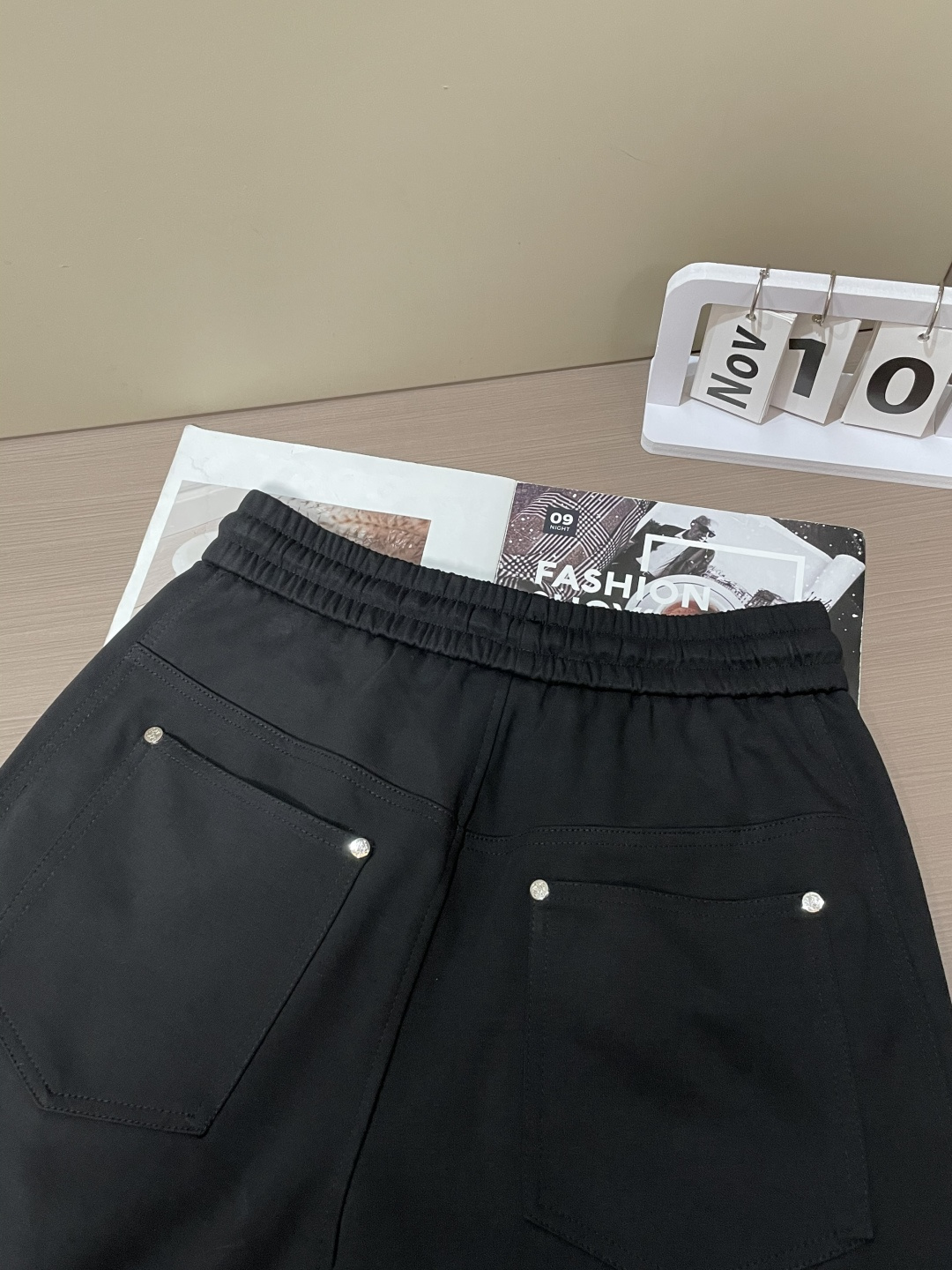 Loewe这条休闲裤，是把“轻奢巧思藏在工装细节里”的款——不是软塌的普通休闲裤，面料带细腻哑光肌理，软