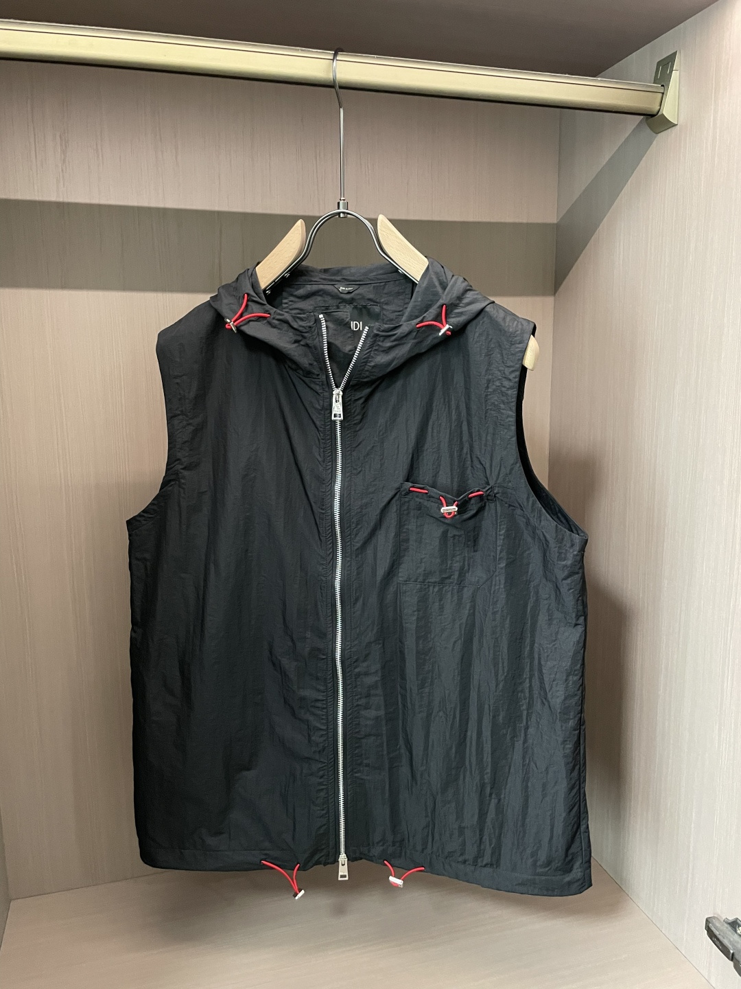 NO:838577,FENDI Hooded Vest | Made of nylon fabric with a slightly wrinkled texture, it has a lightweight and stiff feel, does not weigh down the upper body, is windproof and easy to take care of, and can be used for daily commuting and light outdoor use. The iconic contrasting red rope drawstring is embellished on the brim, pockets and hem. It is a low-key and eye-catching brand detail, breaking the dullness of dark colors and making the whole thing more flexible and energetic.  The hooded + zipper design weakens the rigidity of the vest and brings a casual workwear atmosphere. It is neat and refreshing when worn alone, and it is great when layered with sweatshirts, T-shirts and shirts, easily creating a layered clean fit. Made in Italy, the threads are neatly routed, and the version is resistant to beating. It is an all-purpose item that can be matched repeatedly in the wardrobe and tastes good over time.  Size m-xxl,,fendi,hoodie,sweatshirts,shirts,tees,t-shirt,hats,19860909FENDI 连帽马甲｜微皱肌理的尼龙面料,自带轻量挺括感,上身不压身,防风又好打理,日常通勤、轻户外都能hold住.标志性的撞色红绳抽绳,点缀在帽檐、口袋和下摆处,是低调又亮眼的品牌细节,打破了深色的沉闷,也让整体多了几分灵动活力. 连帽+拉链设计,弱化了马甲的刻板感,自带一点随性的工装氛围.单穿利落清爽,叠搭卫衣、T恤、衬衫都很出彩,轻松打造有层次的clean fit.意大利产的做工,走线利落,版型抗打,是衣柜里能反复搭配、越穿越有味道的万能单品. 尺码m-xxl,,fendi,hoodie,sweatshirts,shirts,tees，t-shirt,hats,,Men's clothing