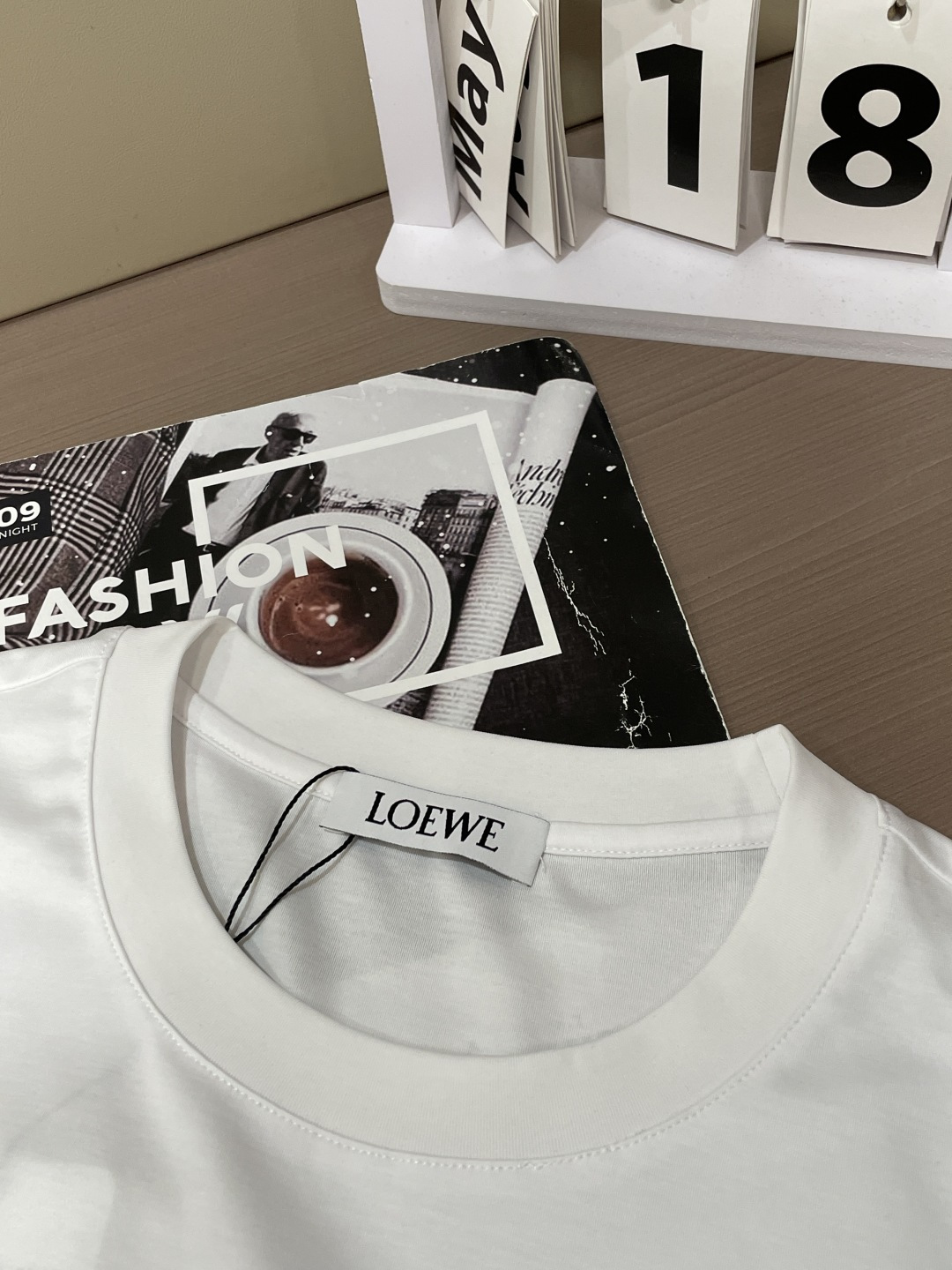 以LOEWE标志性的Anagram为灵感，这件T恤将品牌经典图腾幻化为一枚精致的金色气球刺绣，在极简的底