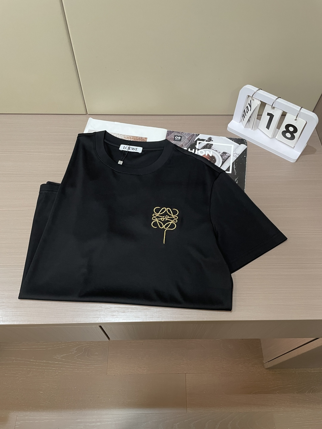 以LOEWE标志性的Anagram为灵感，这件T恤将品牌经典图腾幻化为一枚精致的金色气球刺绣，在极简的底