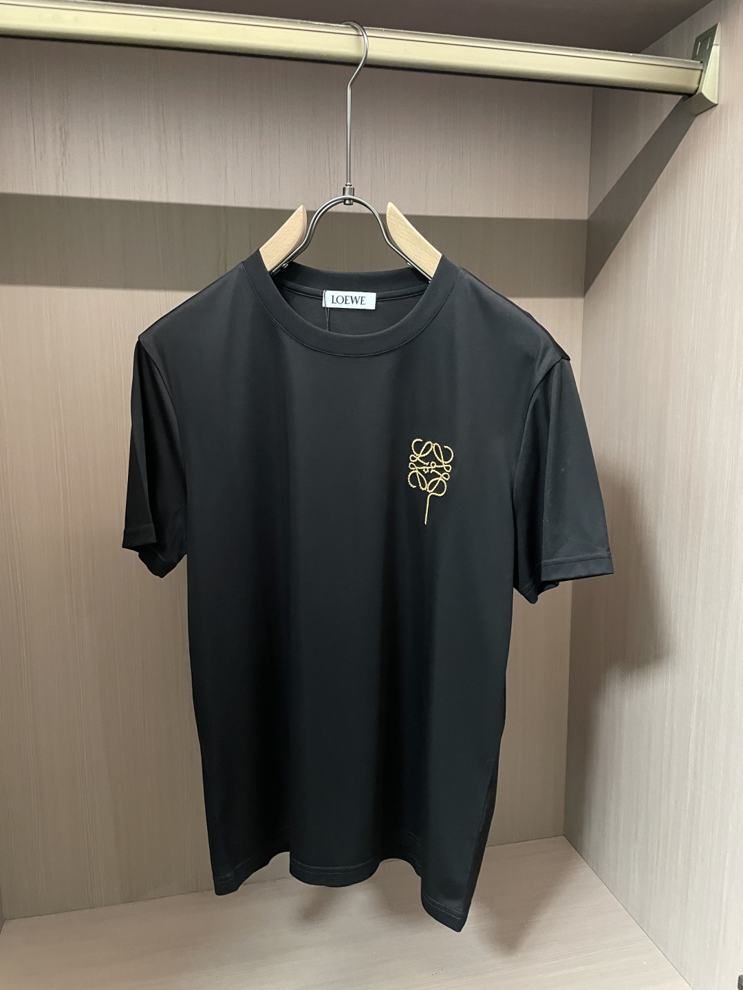 以LOEWE标志性的Anagram为灵感，这件T恤将品牌经典图腾幻化为一枚精致的金色气球刺绣，在极简的底