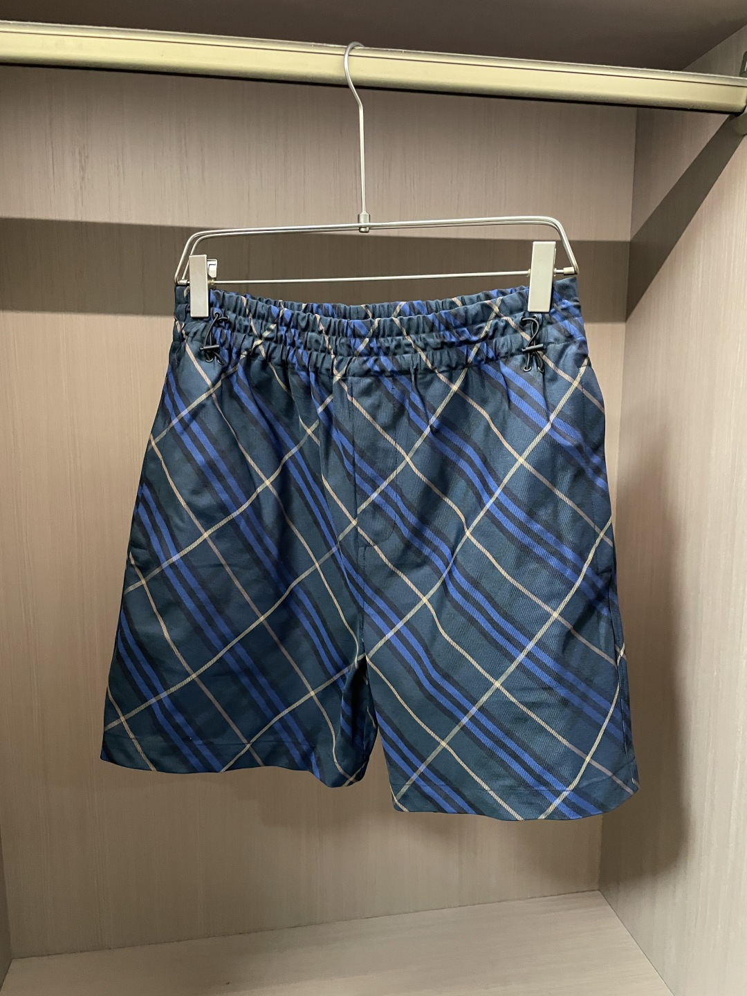 NO:912284,Bur's classic diagonal plaid reshapes the sense of relaxation in summer. It is suitable for home, vacation and daily travel. It is light, breathable and not stuffy on the legs. Men's spring and summer atmosphere shorts. Fabric advantages: Light and thin draping woven blended fabric, with smooth matte texture, light and weightless, breathable and quick-drying, suitable for beach vacations and home relaxation; not easy to wrinkle, not easy to snag, not easy to fade in washing, and the upper body is refreshing and non-sticky. Style and detail design 1.  Retro navy blue bottom with blue and brown diagonal pattern, British retro tone, different from ordinary solid color shorts, the upper body has its own layering; 2. Full-waist elastic drawstring waistband, bilateral adjustment buckles, no waist circumference, can fit both fat and slim body shapes, and can be put on and taken off without restraint; 3. Loose five-point straight pants, covering thigh fat, modifying the leg shape without tightening, and hidden pockets on the side are practical; 4.  The trousers are flat and locked, neatly cut, not clinging to the legs and not looking bloated. They are high-end when worn alone with solid color T-shirts or Polo shirts. Sizes are s-xl, burberry, shorts, tees, t-shirt,19860909Bur 经典斜向格纹重塑夏日松弛感,兼顾居家、度假、日常出行,轻薄透气不闷腿,男士春夏氛围感短裤. 面料优势 轻薄垂顺梭织混纺面料,自带顺滑哑光质感,轻盈无负重,透气速干,海边度假、居家休憩都适配；不易皱、不易勾丝,水洗不易掉色,上身清爽不粘肤. 版型与细节设计 1. 复古藏青底撞蓝棕斜格纹,英伦复古调性,区别普通纯色短裤,上身自带穿搭层次； 2. 全腰松紧抽绳腰头,双侧调节扣,不挑腰围,微胖、偏瘦身形都能贴合,穿脱无束缚； 3. 宽松五分直筒裤长,遮住大腿赘肉,修饰腿型不紧绷,侧边隐形口袋兼顾实用性； 4. 平整锁边裤脚,剪裁利落,不贴腿不显臃肿,单穿搭配纯色T恤、Polo衫都高级. 尺码s-xl,,burberry,shorts,tees，t-shirt,,Men's clothing